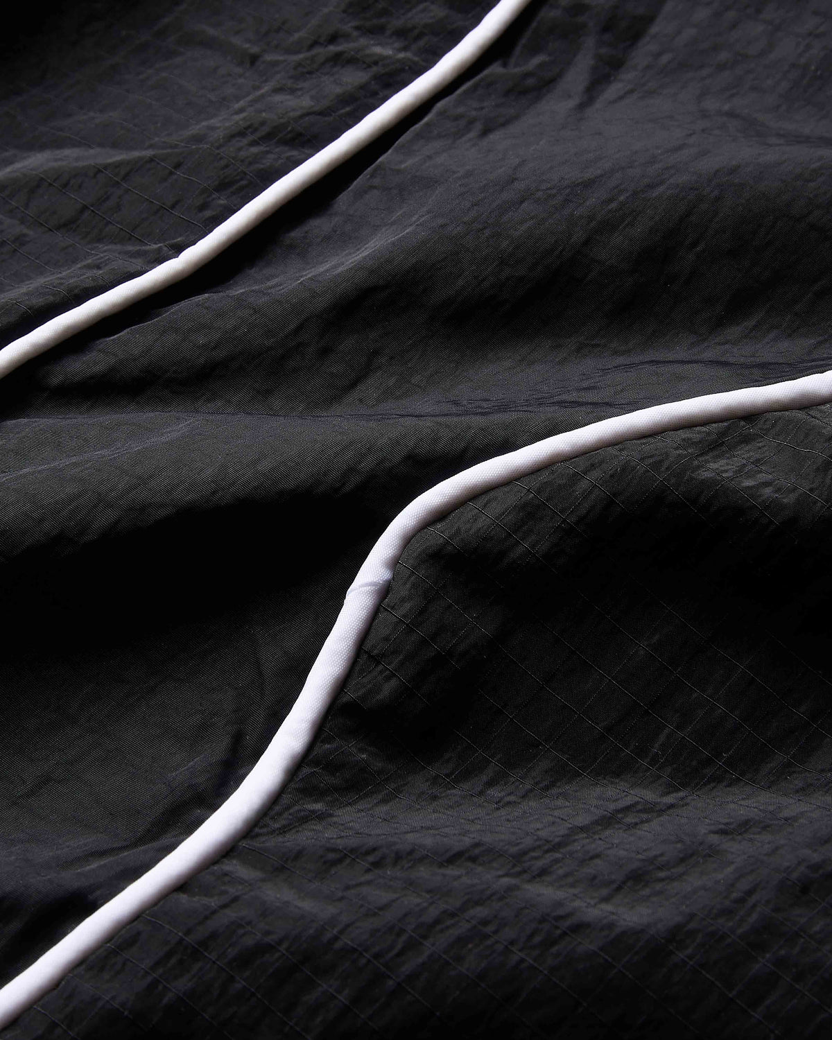 Close-up of black fabric with white cables on a dark background