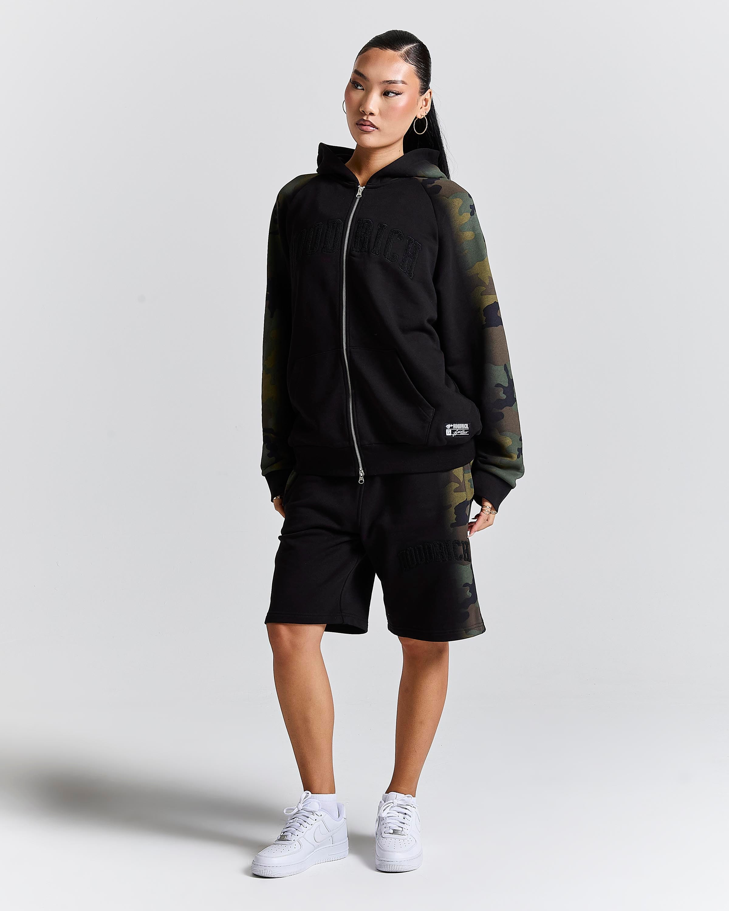 Displays a model wearing the Black camo 'Hoodrich' branded women's Shade Matching Shorts Set