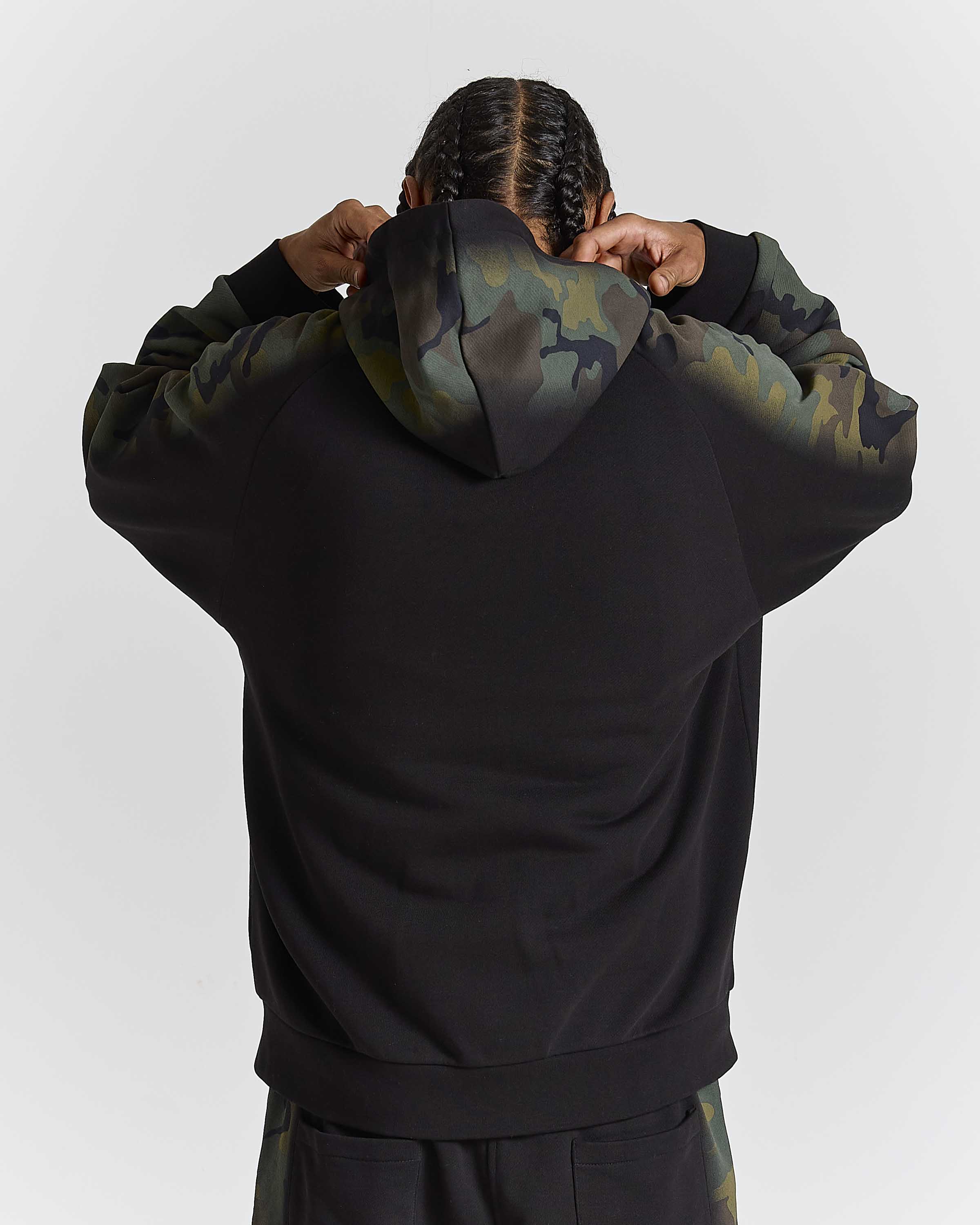 Displays a model wearing the Black Camo 'Hoodrich' branded men's Shade Matching Shorts Set