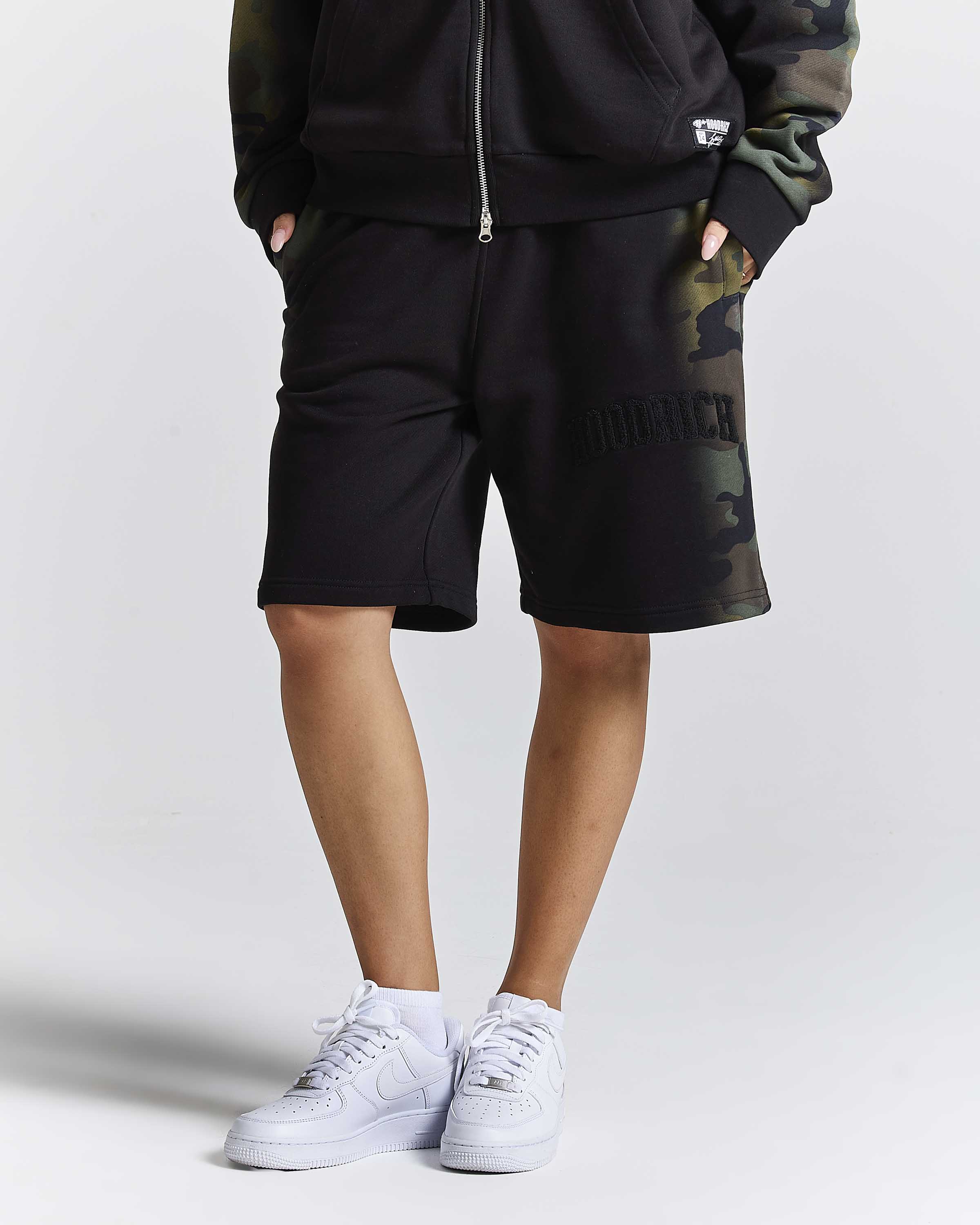 Displays a model wearing the Black camo 'Hoodrich' branded women's Shade Matching Shorts Set