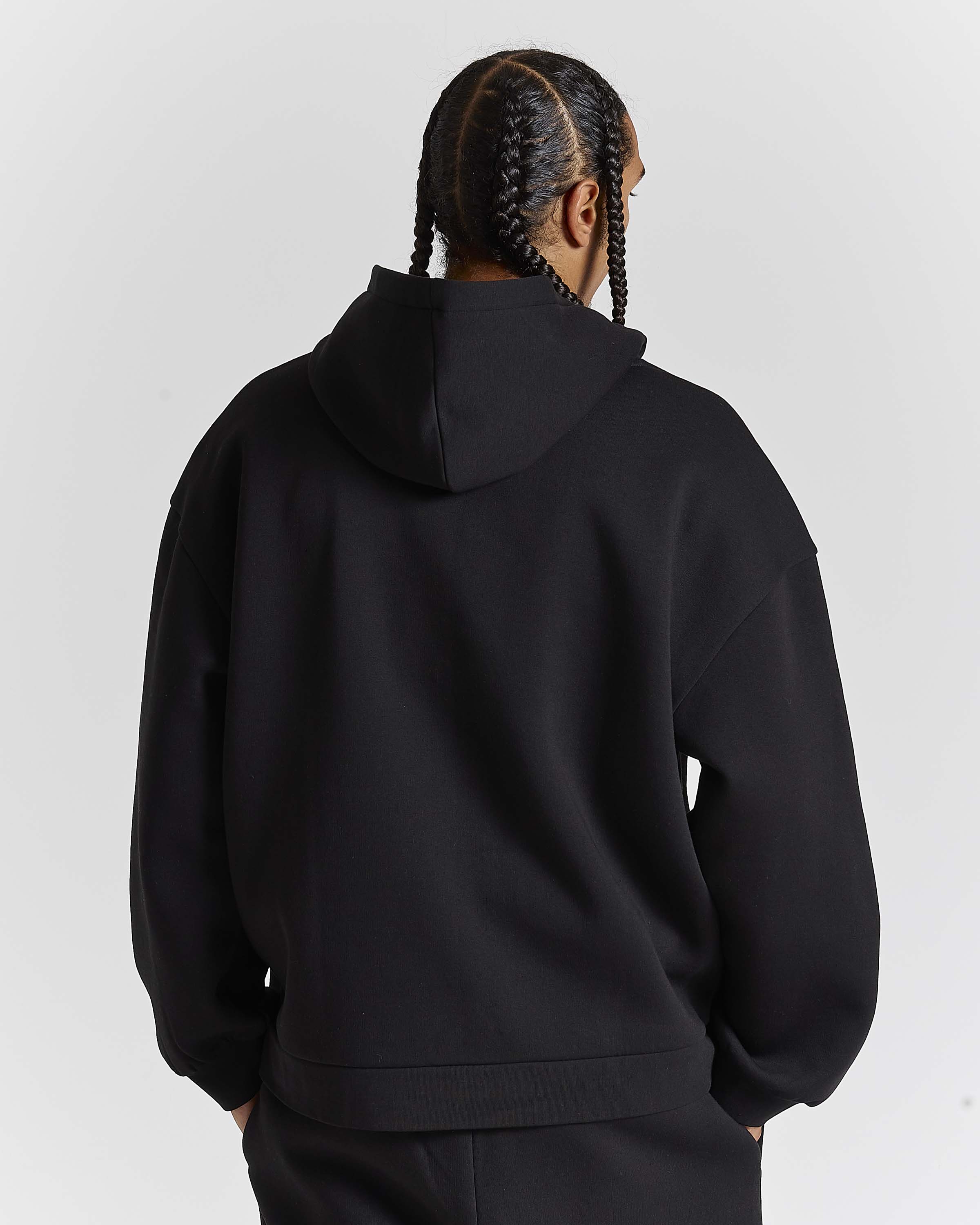 Displays a model wearing the Black 'Hoodrich' branded men's Aegis Full Tracksuit