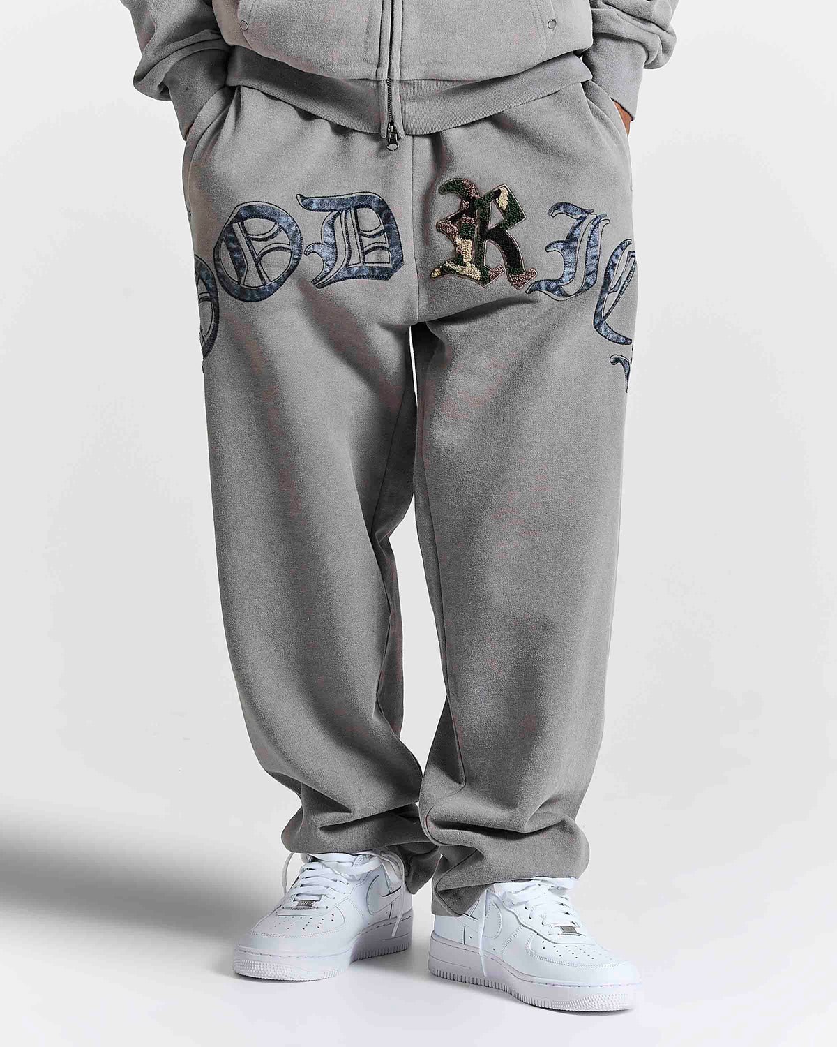 Displays a model wearing the Grey 'Hoodrich' branded men's Inkfall Full Tracksuit