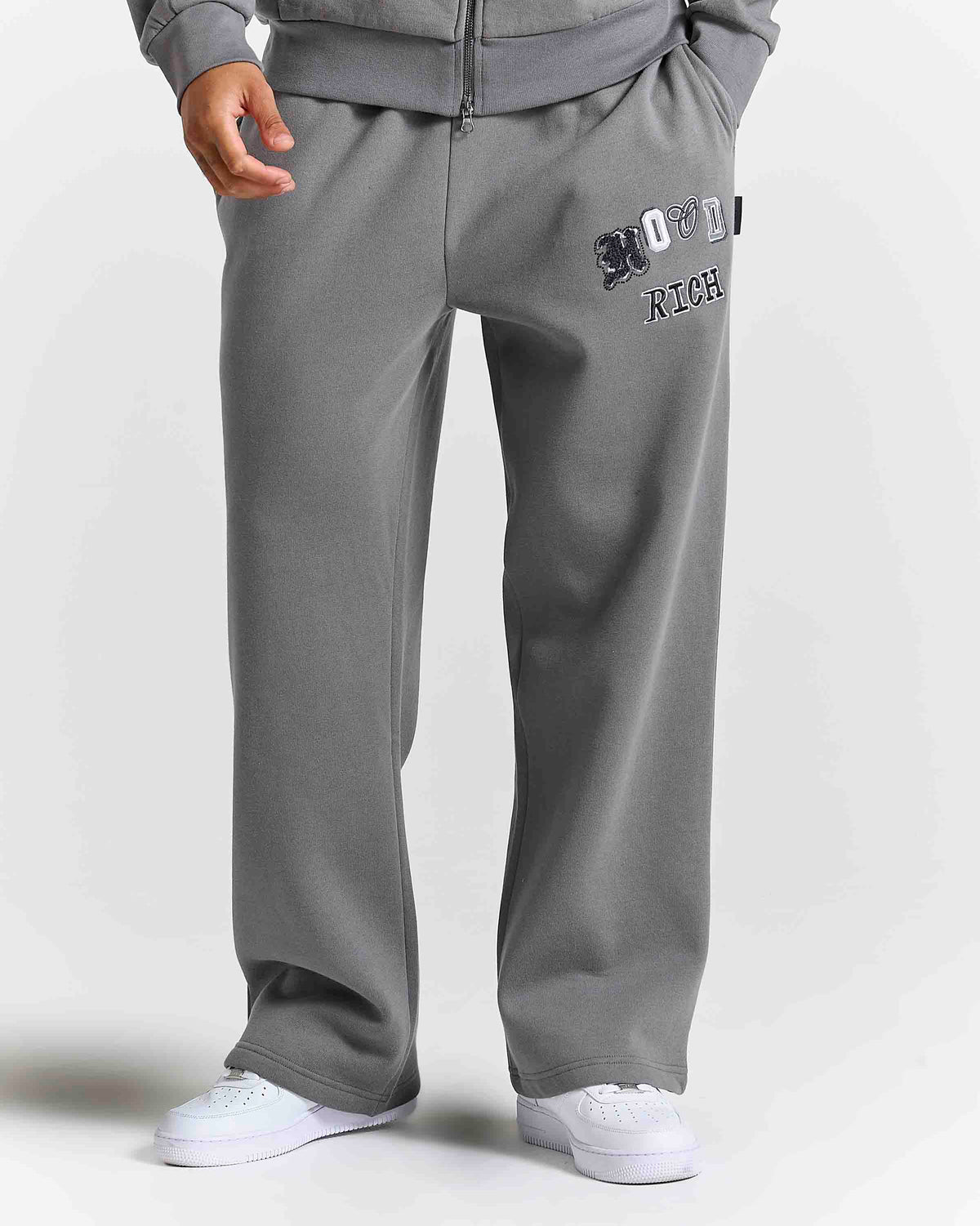 Displays a model wearing the grey lava smoke 'Hoodrich' branded Forza Oversized Wide Leg Jogger