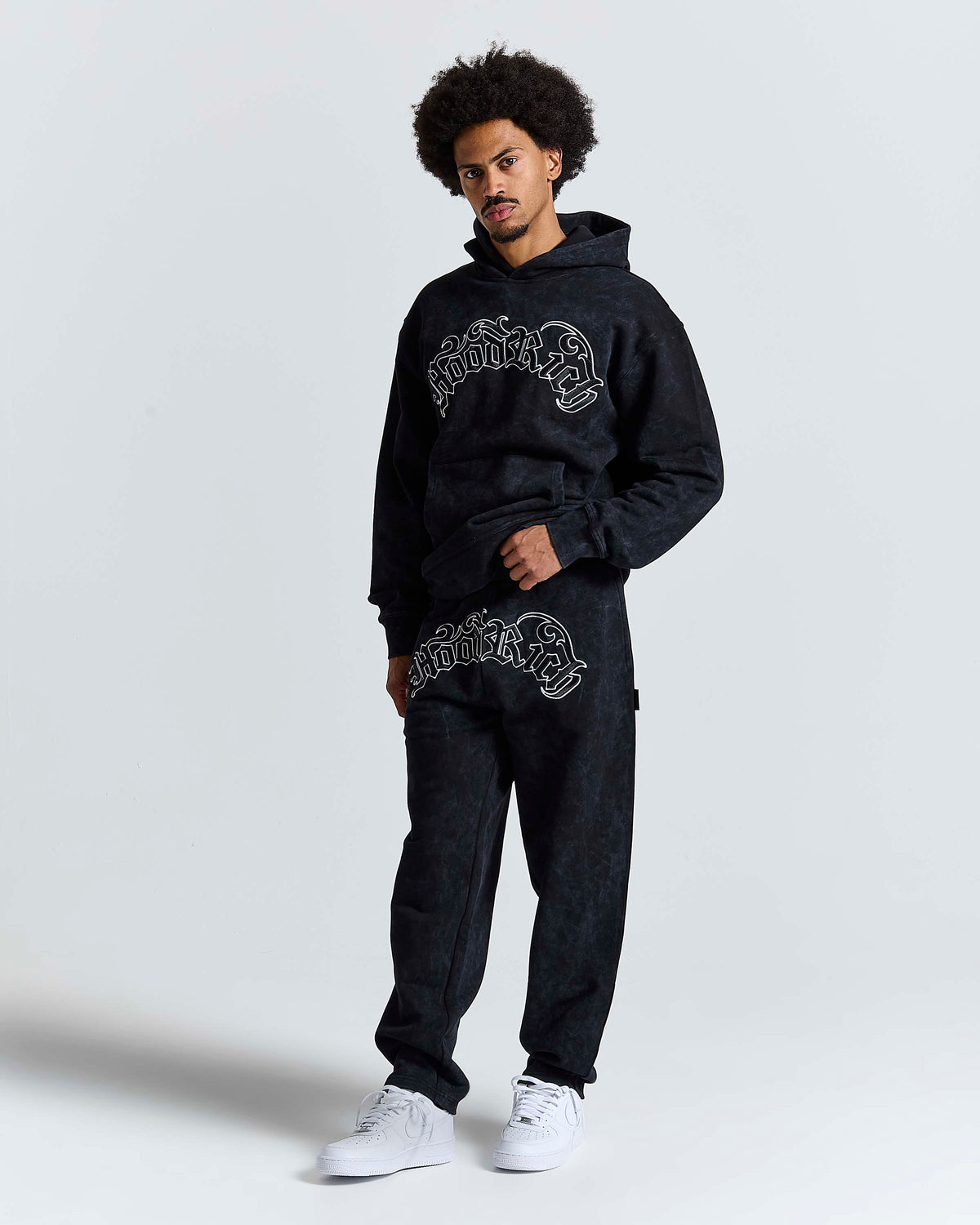 Displays a model wearing the Black 'Hoodrich' branded men's Nocturn Full Tracksuit