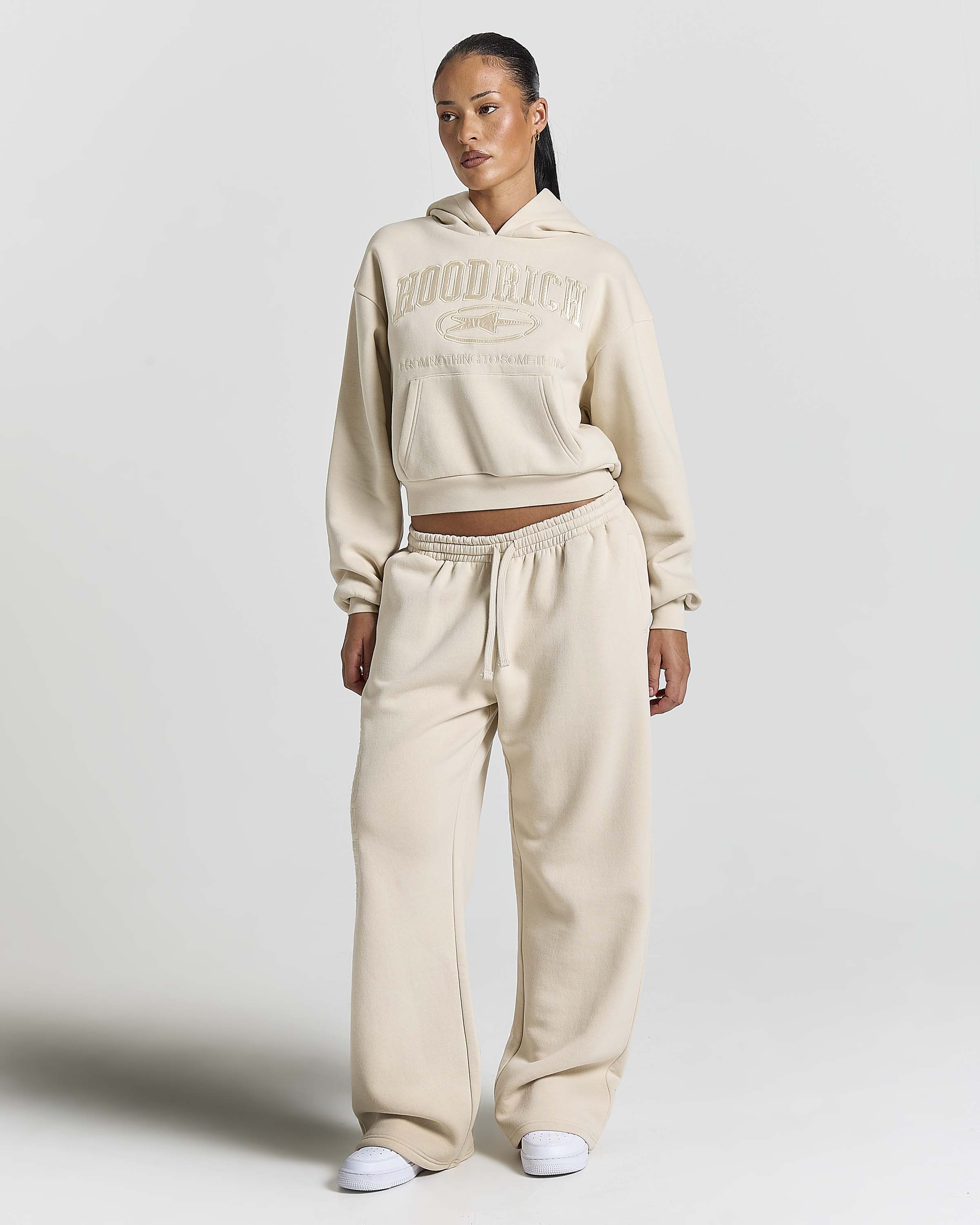 Displays a model wearing the Stone 'Hoodrich' branded women's Aegis Full Tracksuit