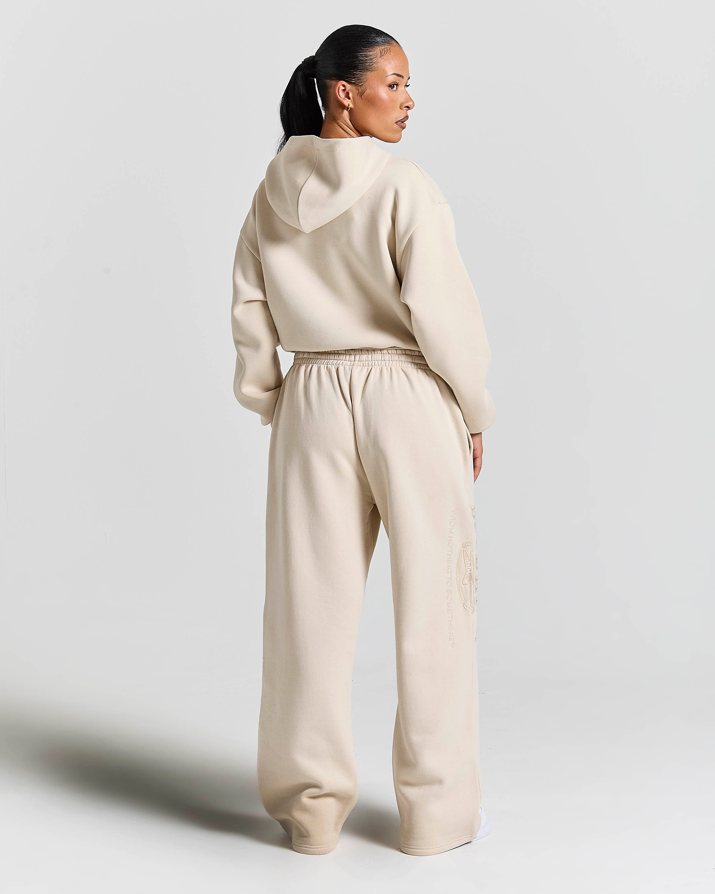 Displays a model wearing the Stone 'Hoodrich' branded women's Aegis Full Tracksuit