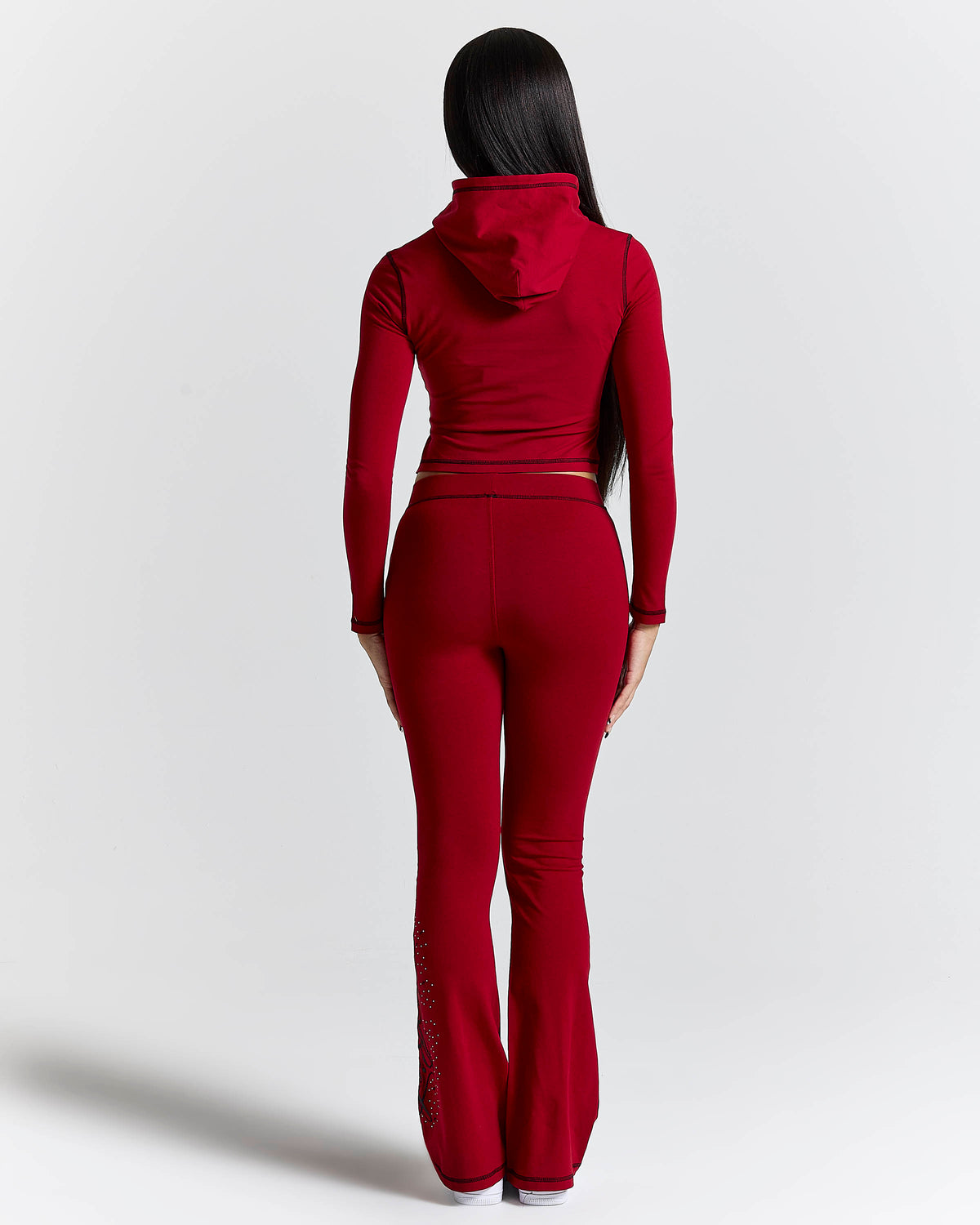 Displays a model wearing the red 'hoodrich' branded Gleam Flare Legging
