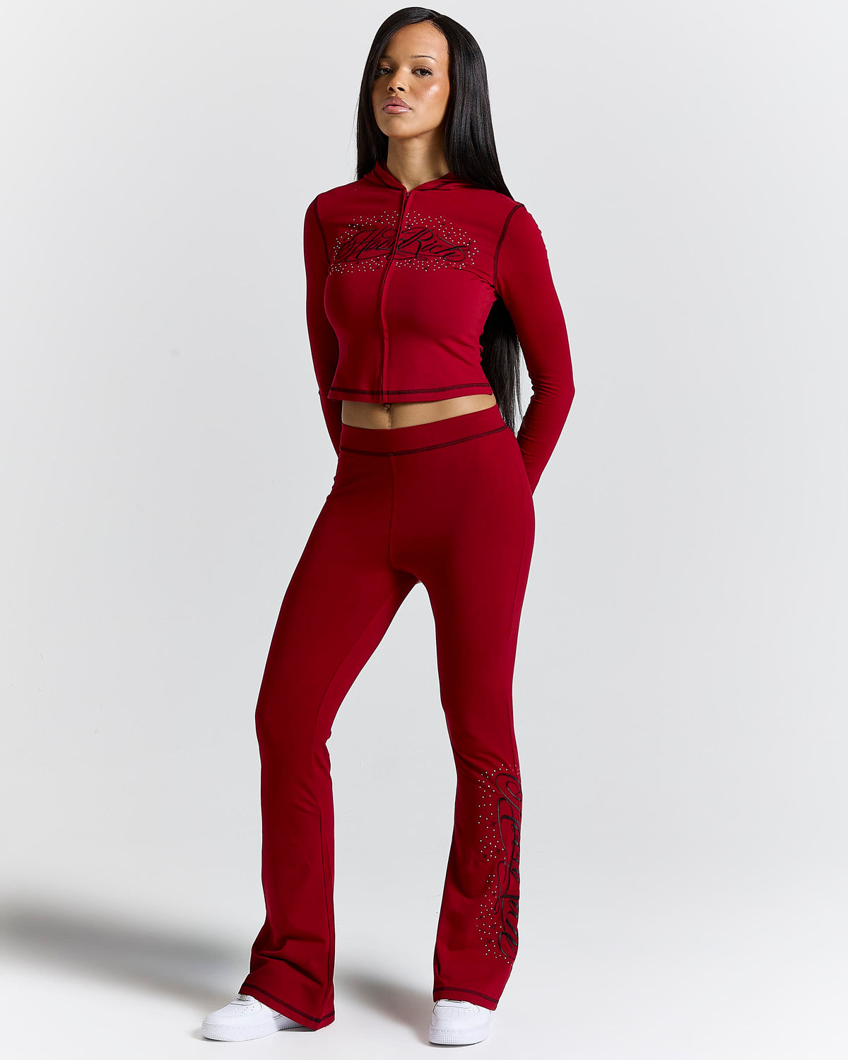 Displays a model wearing the red 'hoodrich' branded Gleam Flare Legging