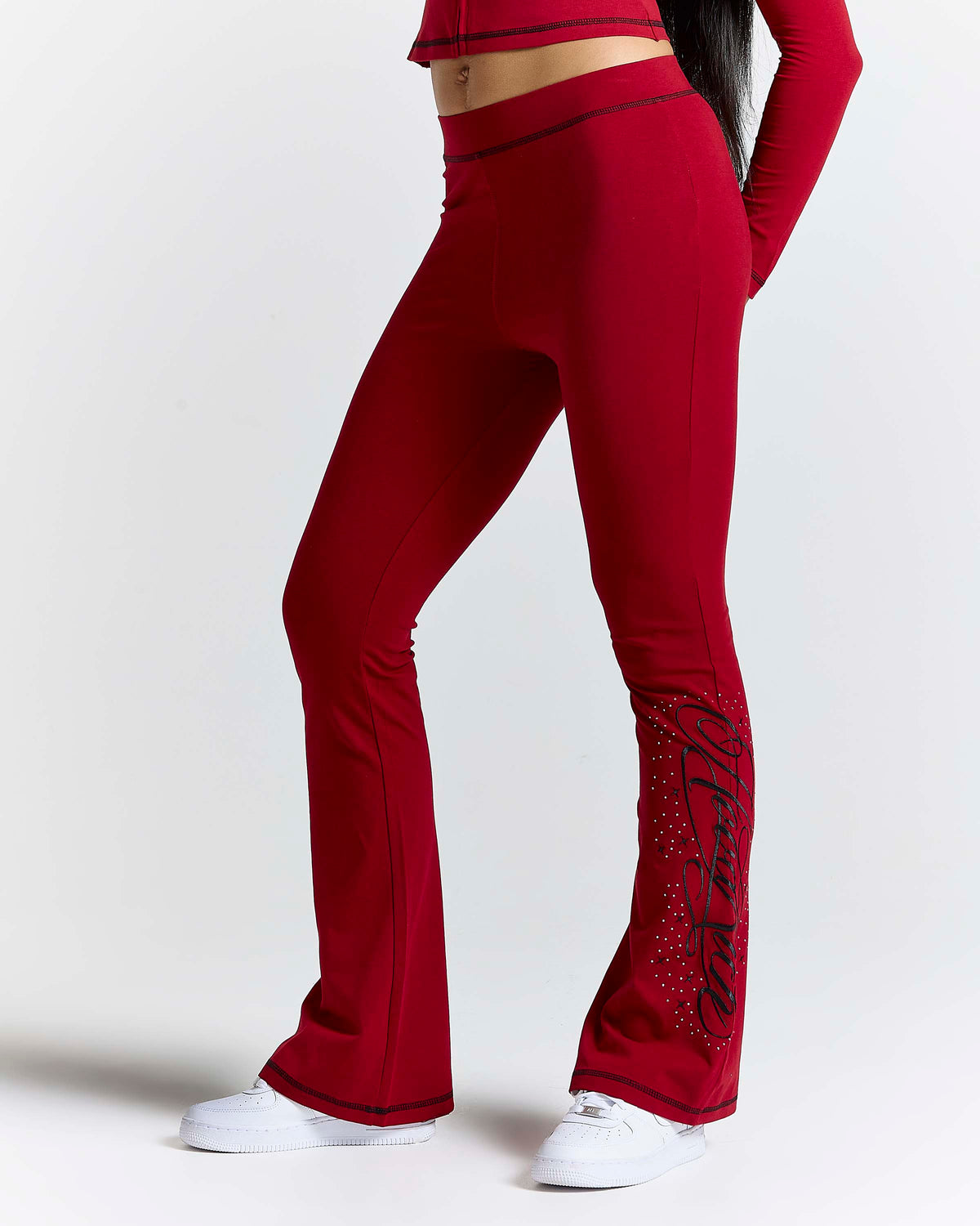 Displays a model wearing the red 'hoodrich' branded Gleam Flare Legging