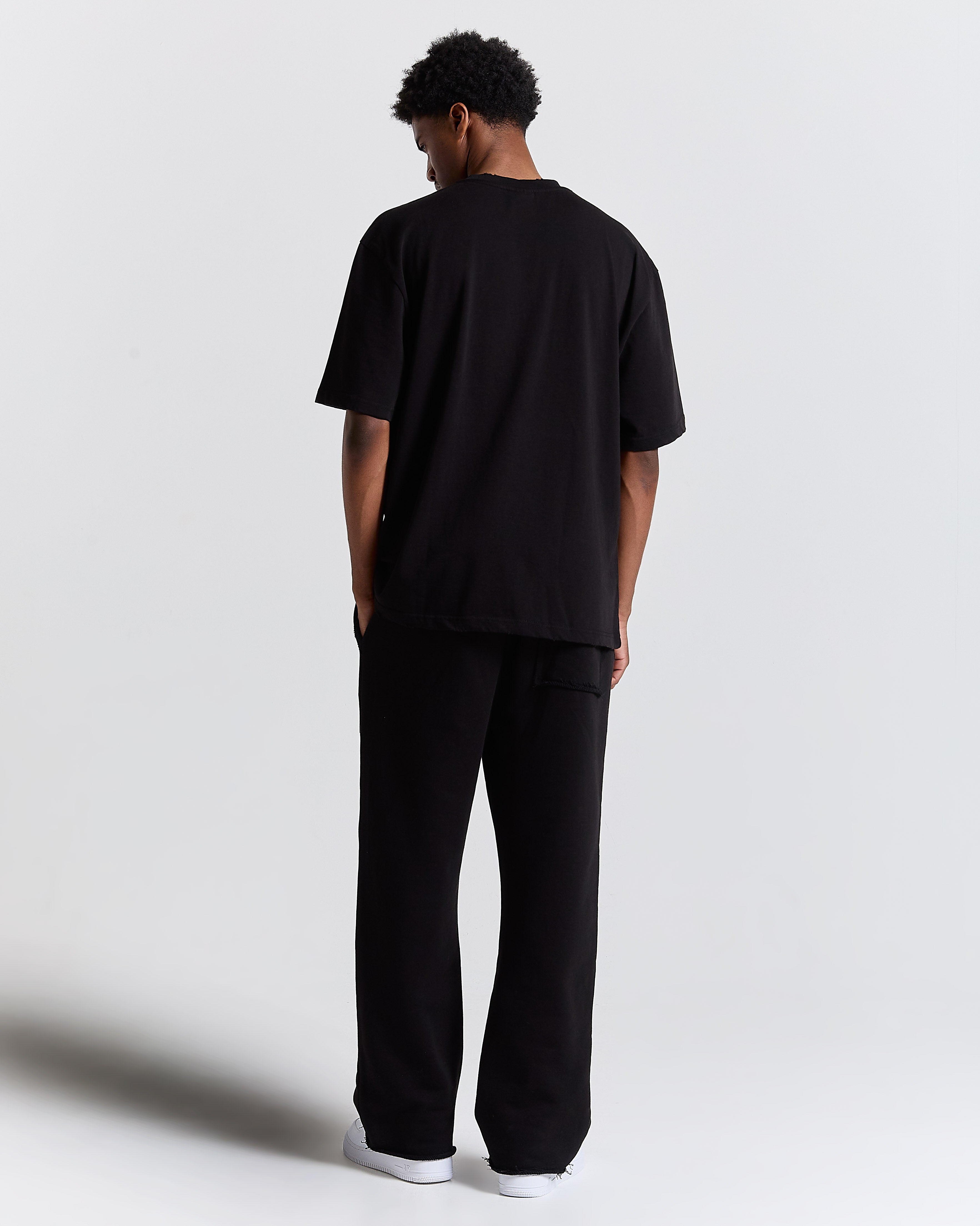 Person wearing a black outfit on a plain background
