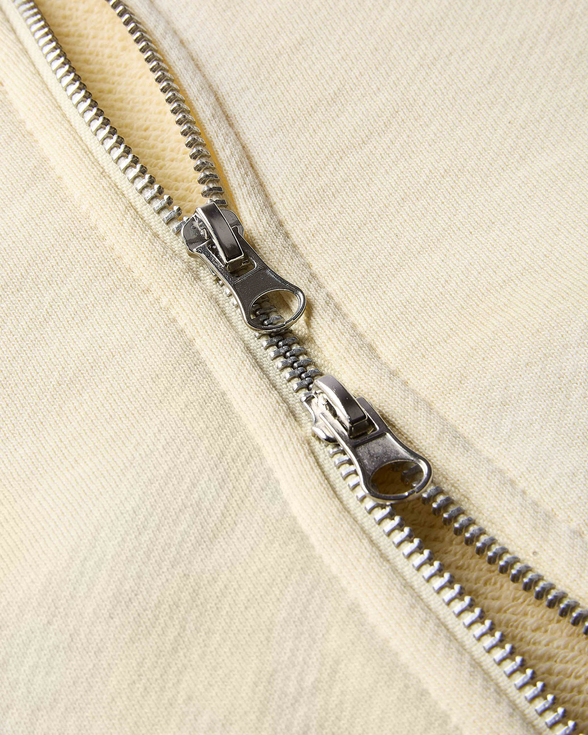 Close-up of a zipper on a beige fabric background