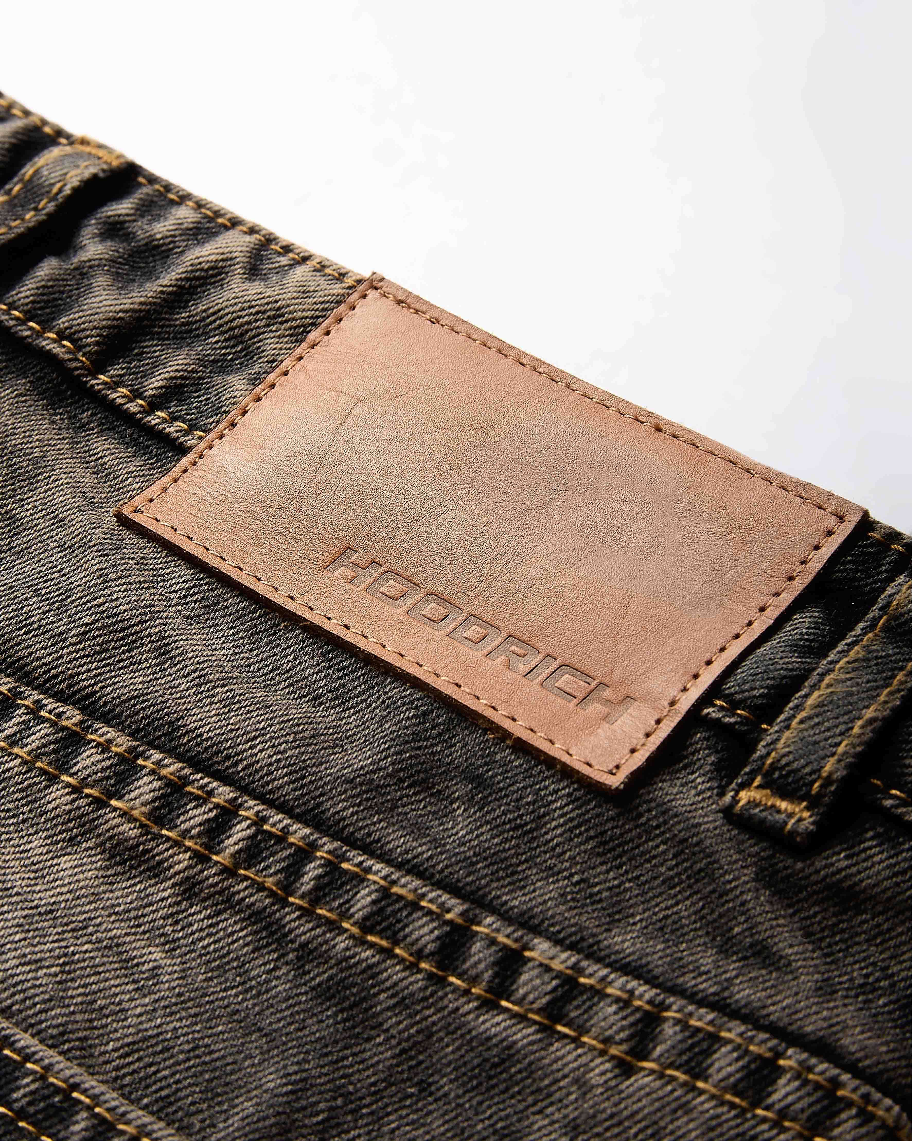 Close-up of the metal button and rivet detailing on the regular fit black rust washed denim jorts.