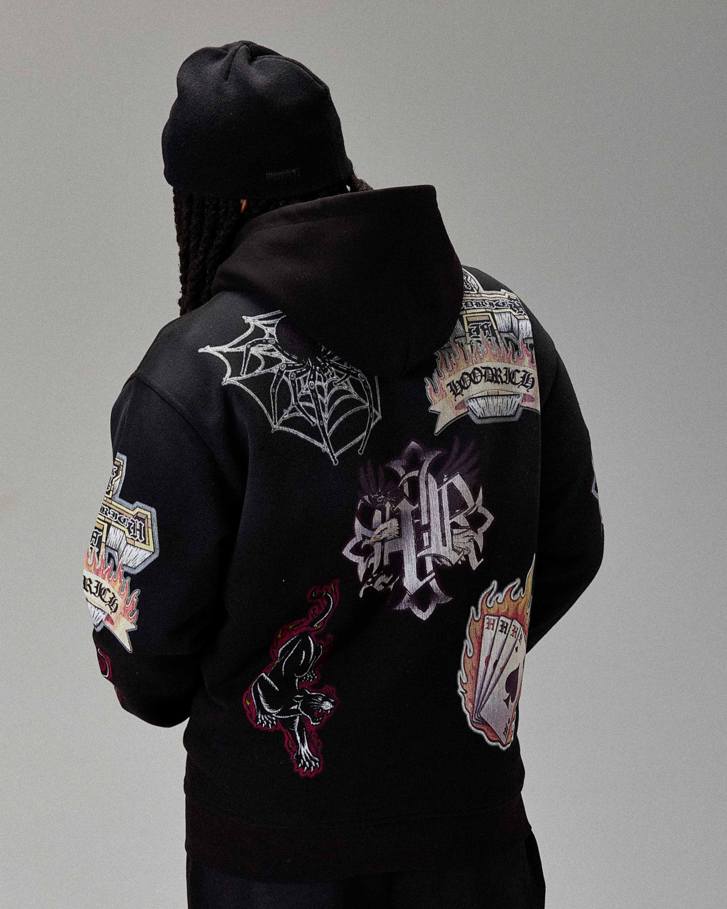 Black hoodie with colorful patches on a gray background