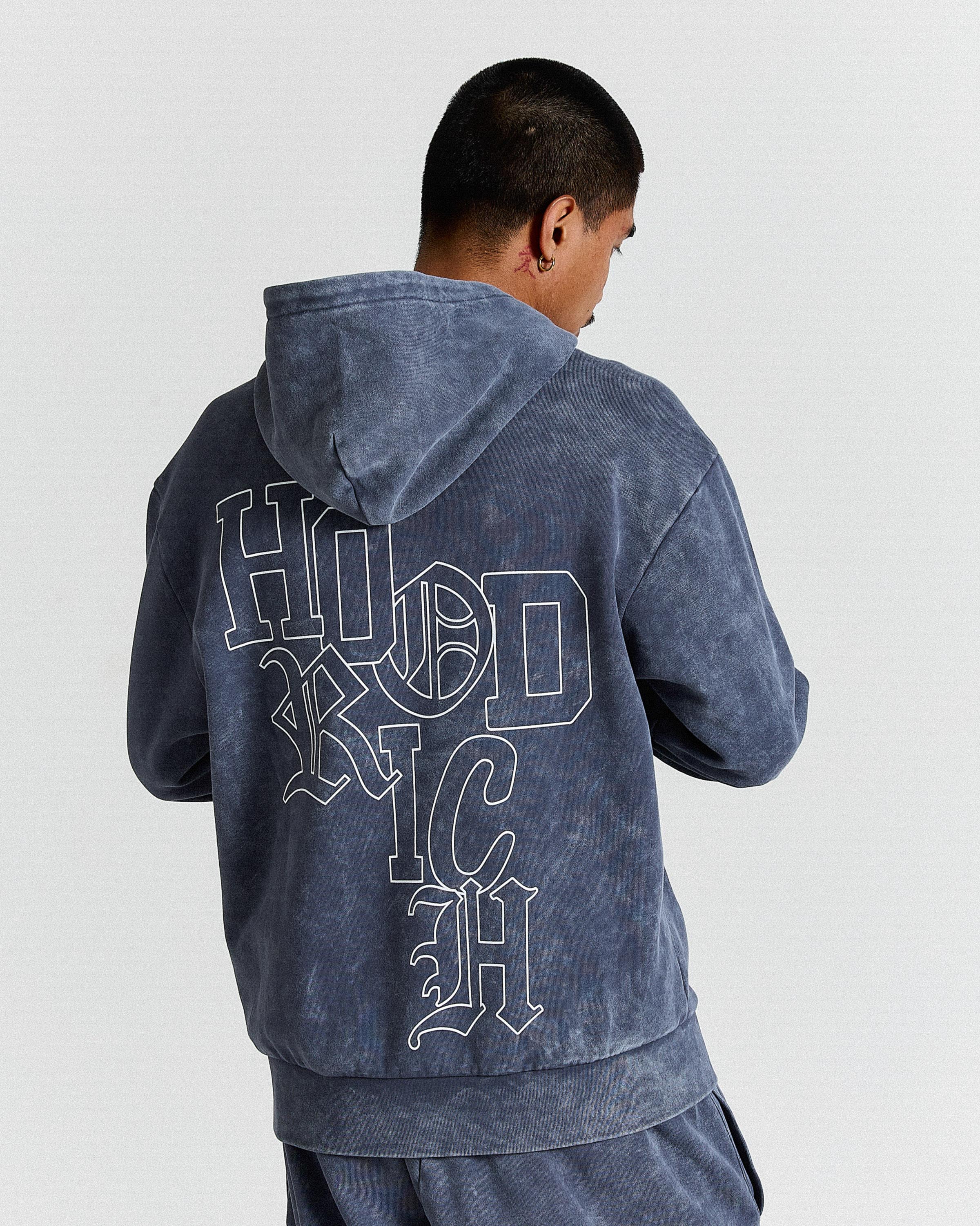 Person wearing a blue hoodie with 'HOODRICH' text on the back against a white background