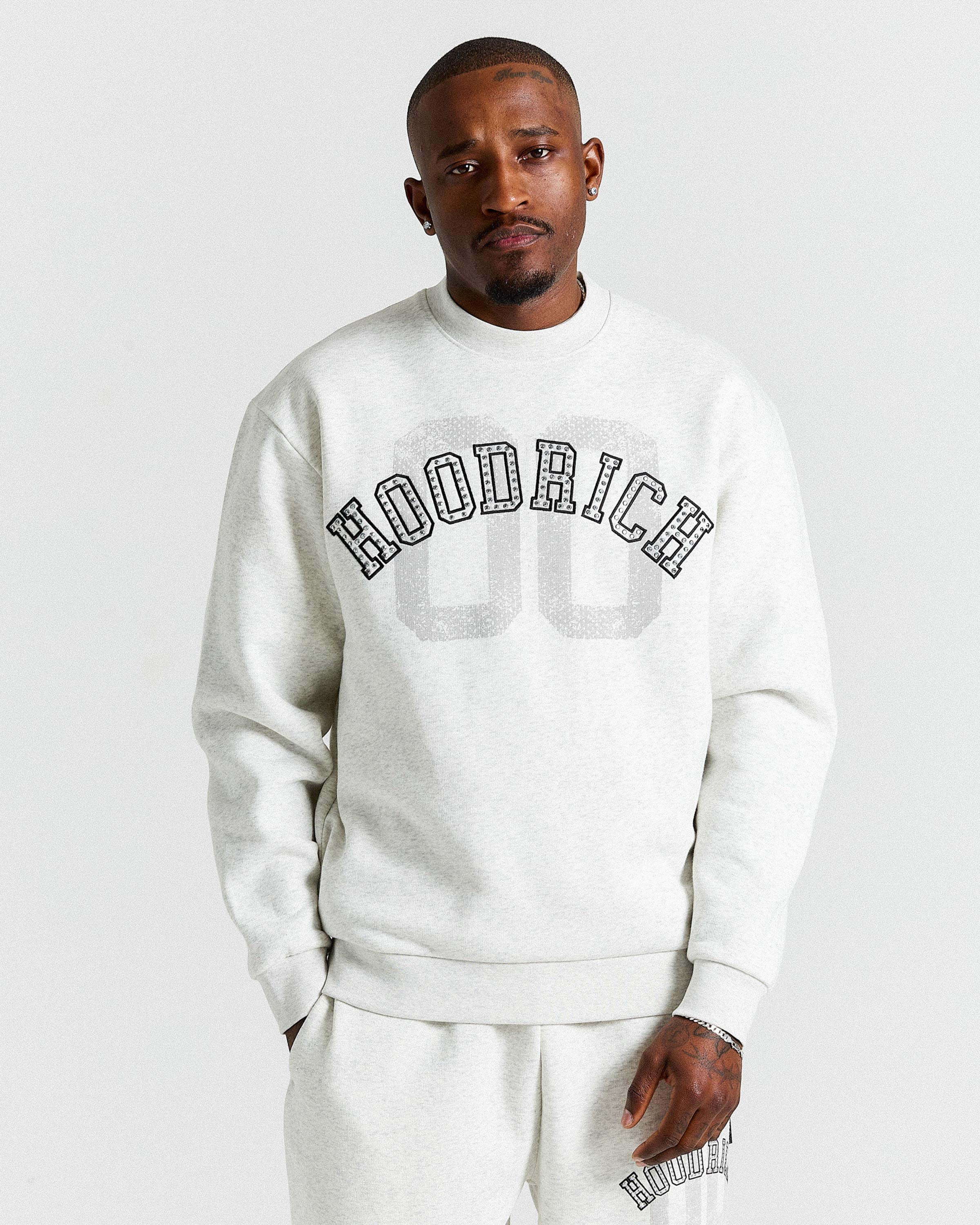 Displays a model wearing the Grey & Black 'Hoodrich' branded men's Rivet Full Tracksuit