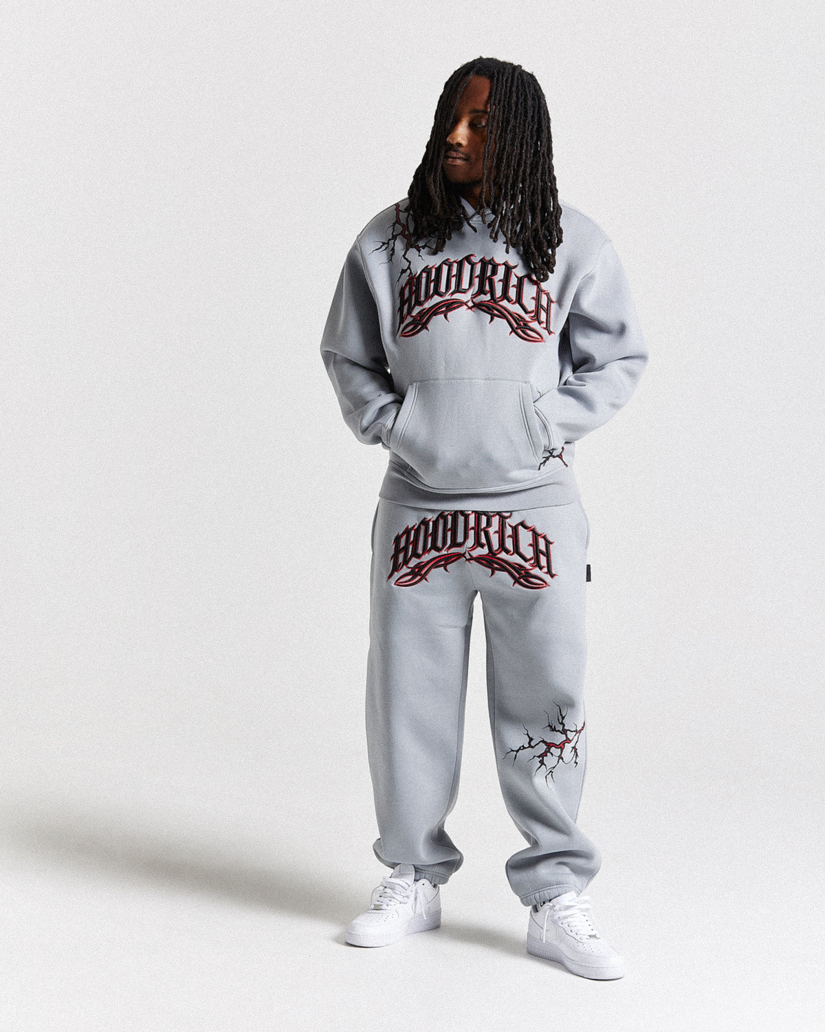 Displays a model wearing the Grey 'Hoodrich' branded men's Dark Full Tracksuit