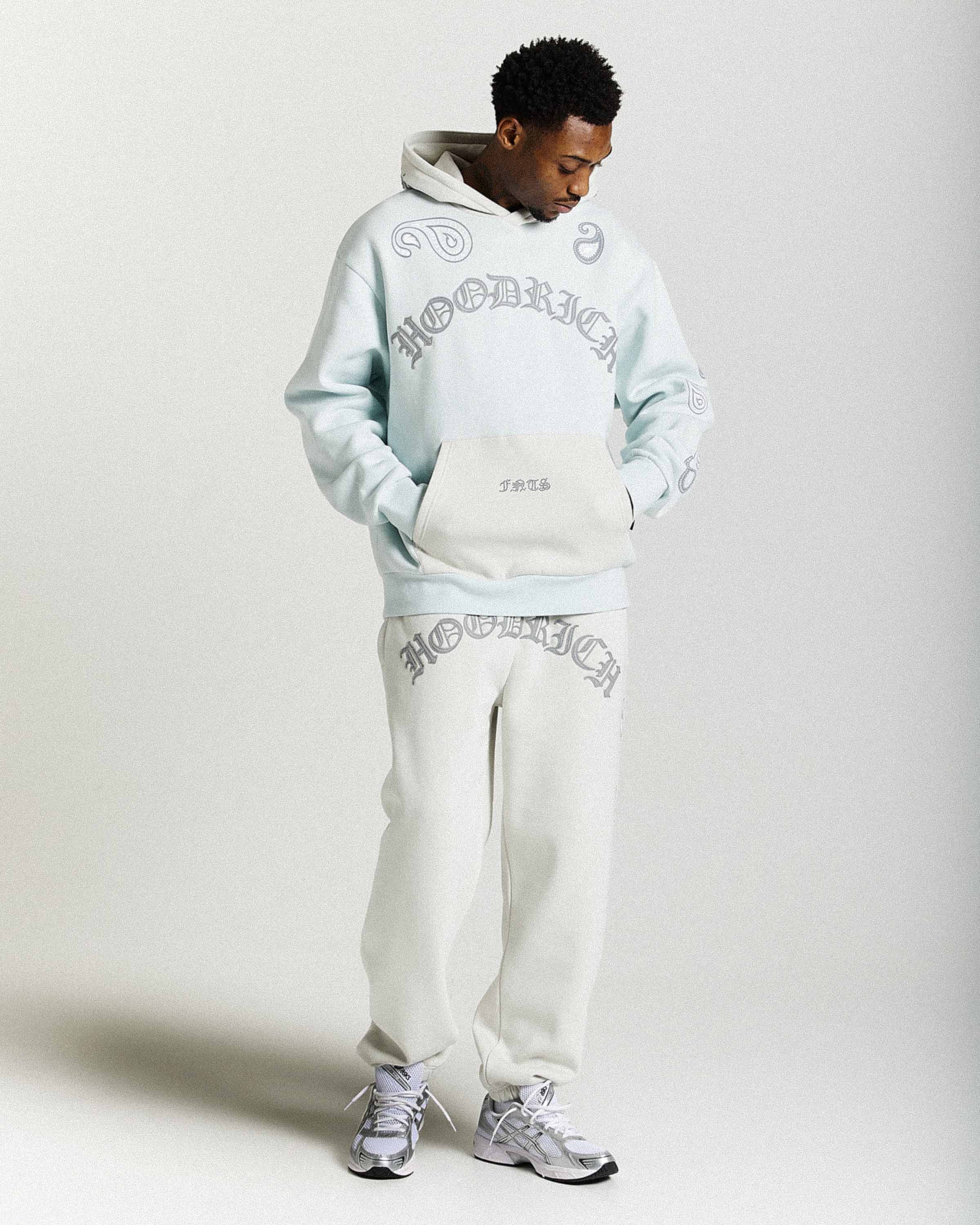 Displays a model wearing the Grey 'Hoodrich' branded men's Inkline Full Tracksuit