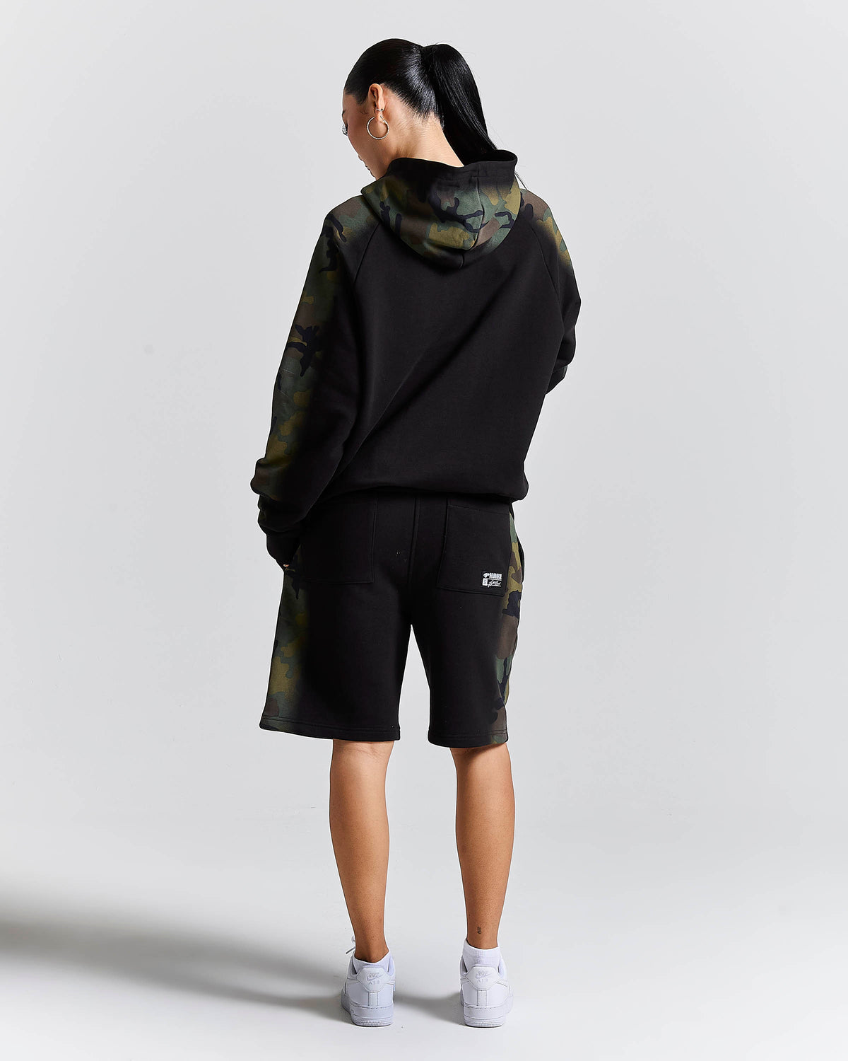 Displays a model wearing the Black camo 'Hoodrich' branded women's Shade Matching Shorts Set
