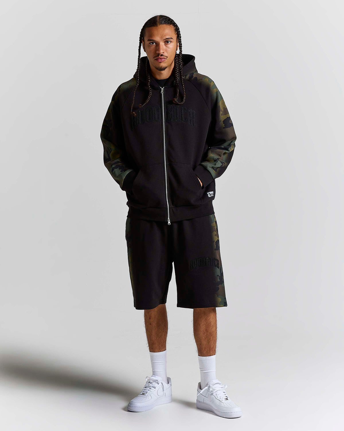 Displays a model wearing the Black Camo 'Hoodrich' branded men's Shade Matching Shorts Set 