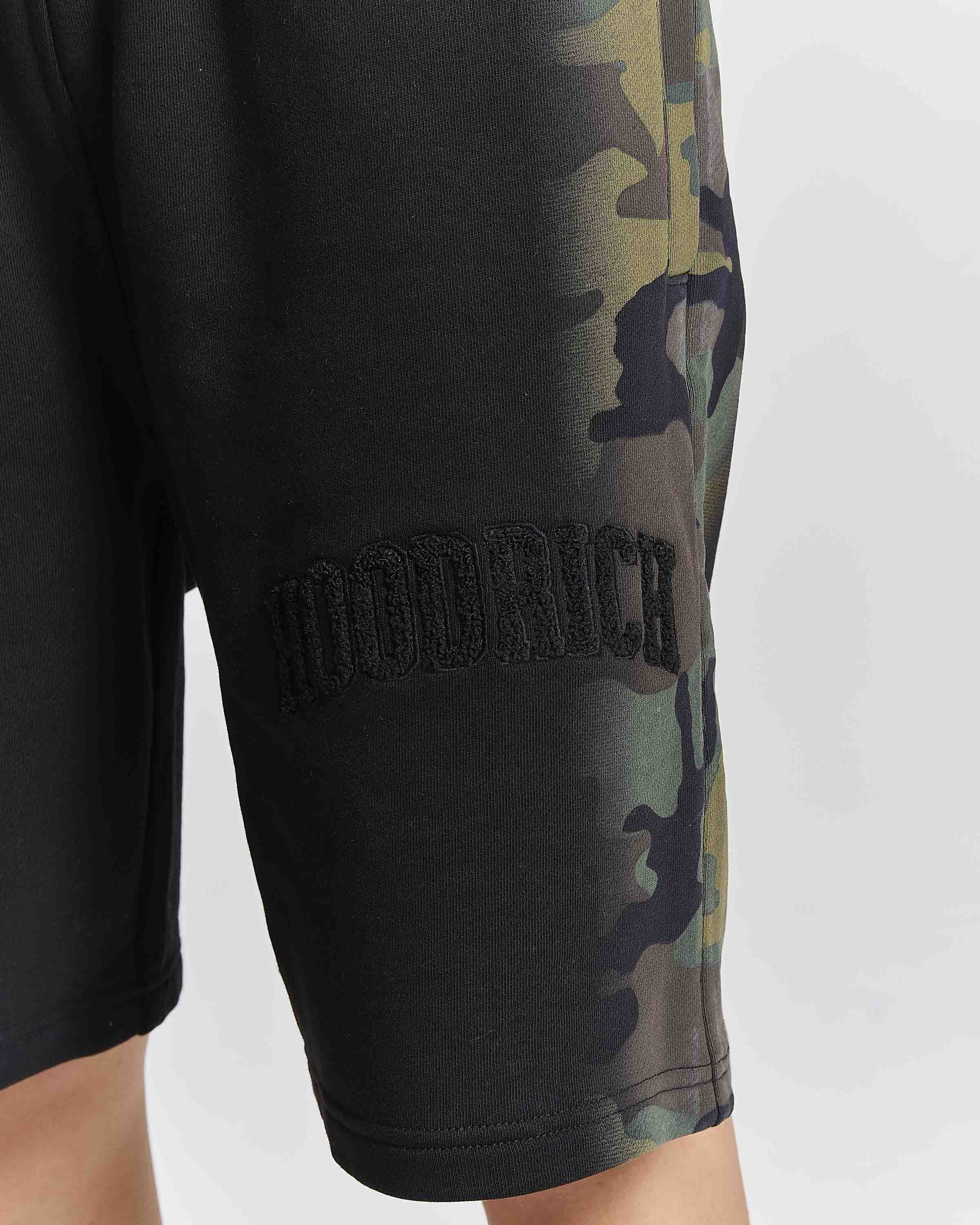 Displays a model wearing the Black camo 'Hoodrich' branded women's Shade Matching Shorts Set
