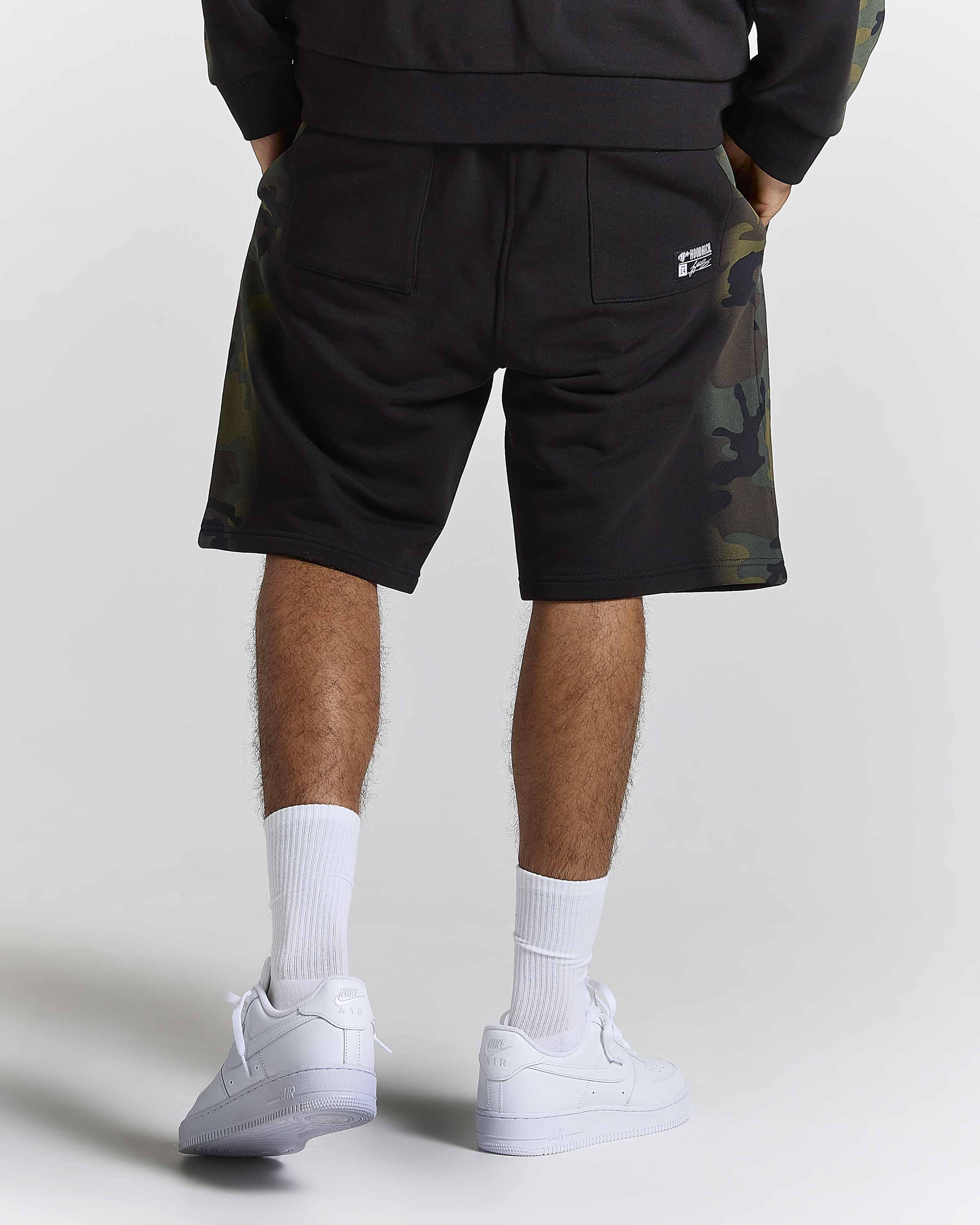 Displays a model wearing the Black Camo 'Hoodrich' branded men's Shade Matching Shorts Set 