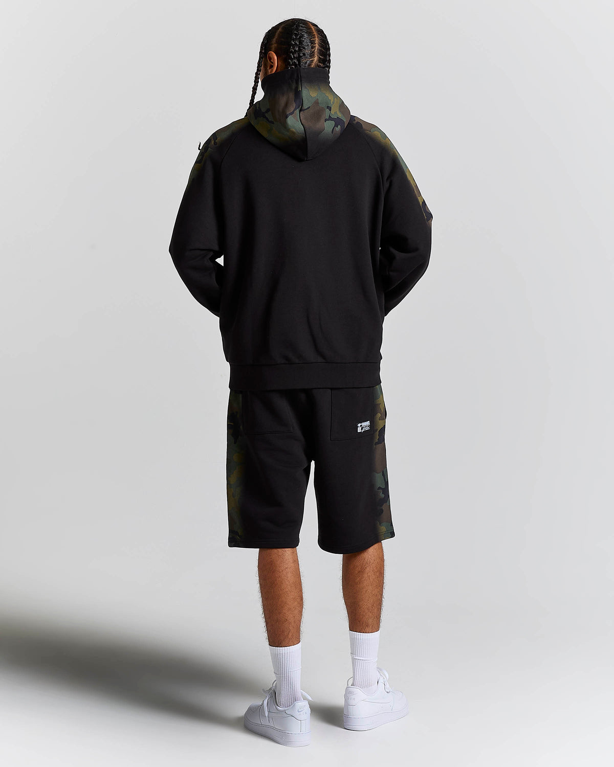 Displays a model wearing the Black Camo 'Hoodrich' branded men's Shade Matching Shorts Set 
