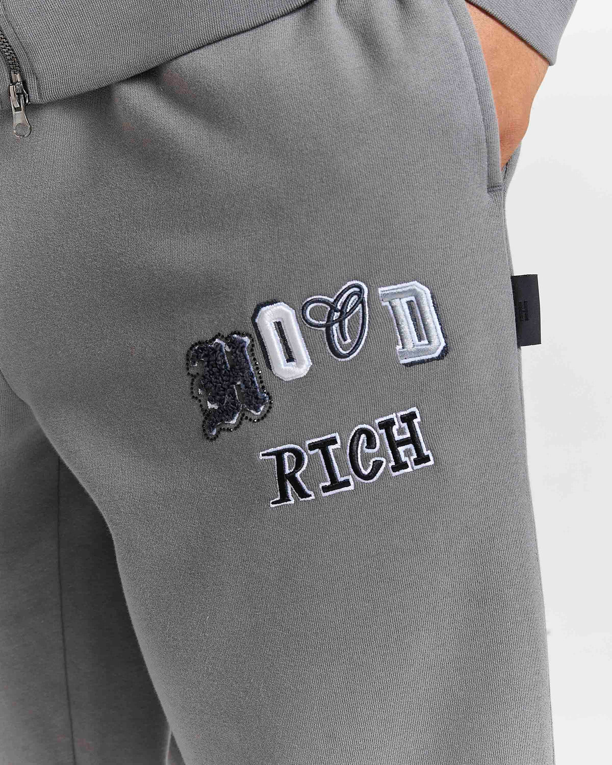 Displays a model wearing the grey lava smoke 'Hoodrich' branded Forza Oversized Wide Leg Jogger featuring the hoodrich branding details