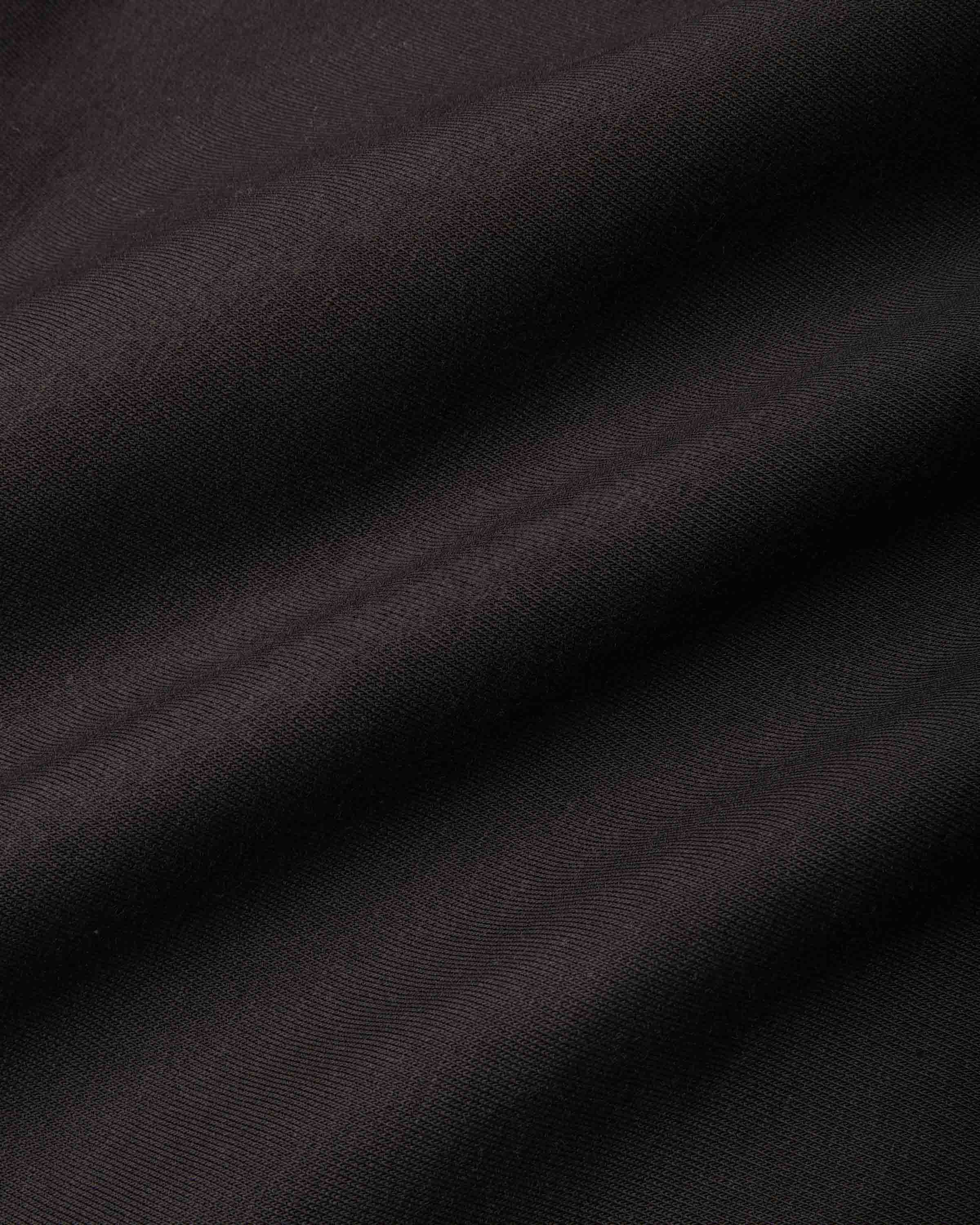A close-up of dark, draped fabric with a fine ribbed texture, showing soft folds and shadows.