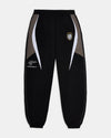 Black tracksuit pants with white and gray accents on a light gray background