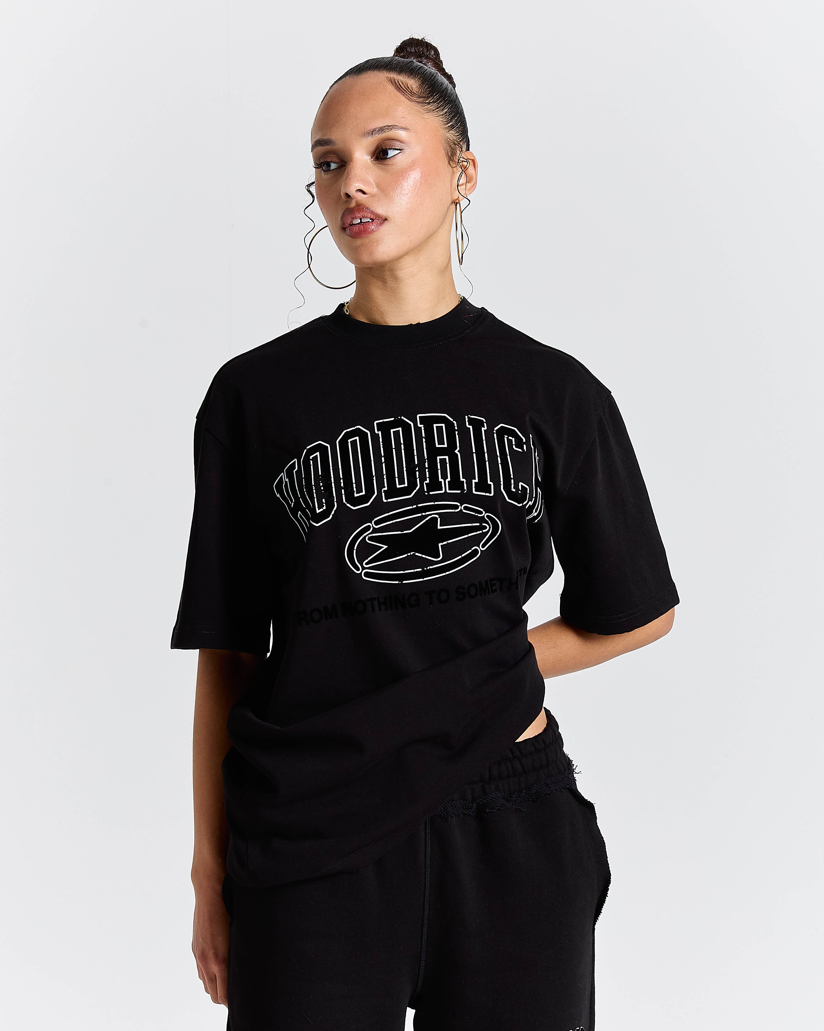 Person wearing a black t-shirt with 'Hoodrich branding on a white background
