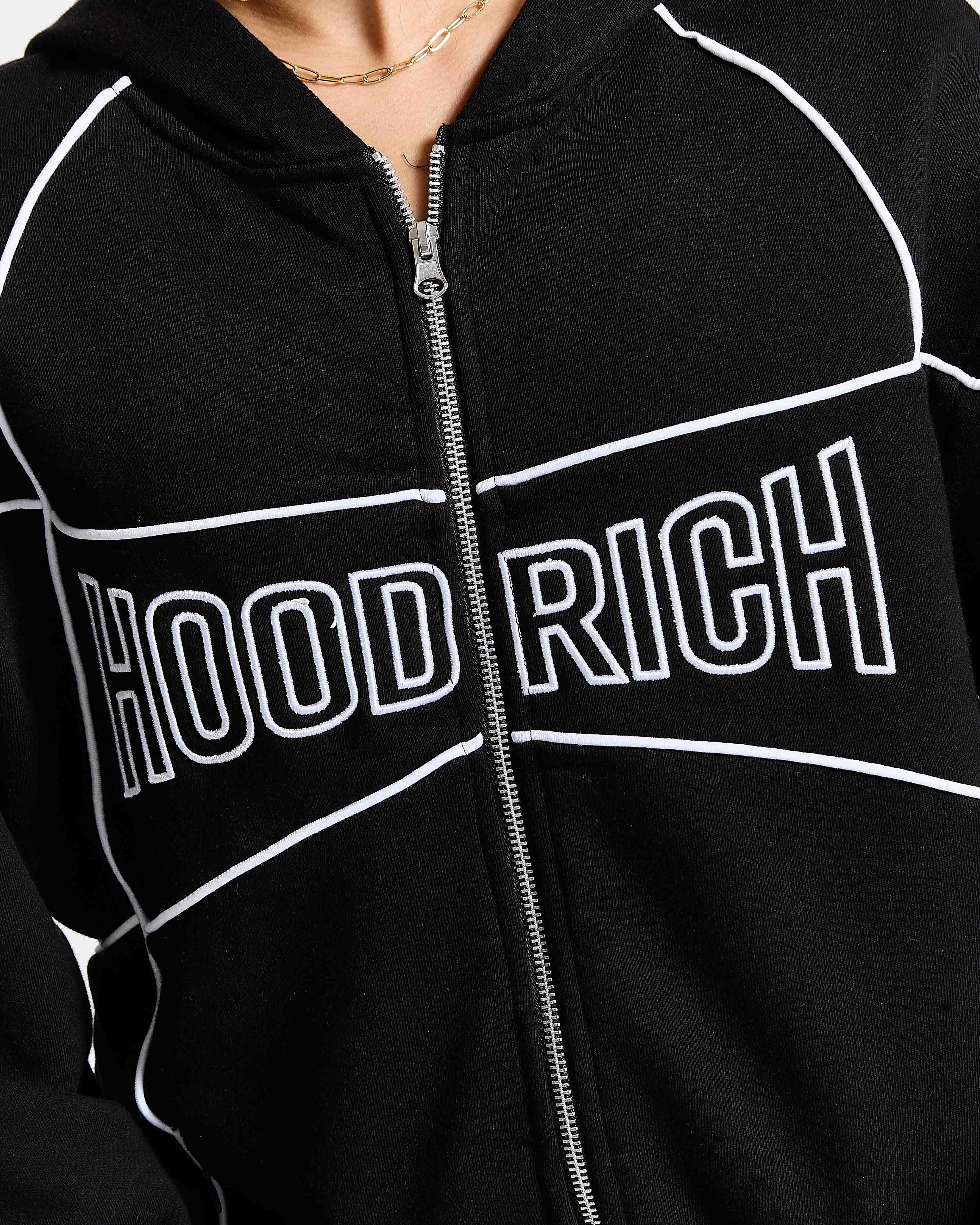 Black hoodie with 'HOOD RICH' text on a person wearing it.