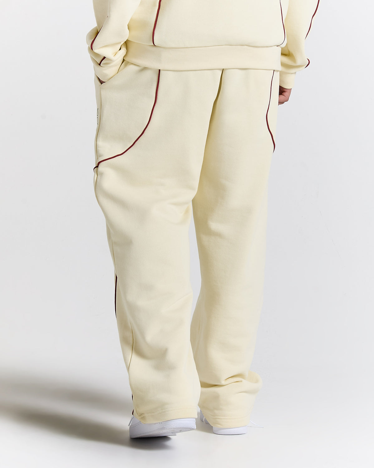 Beige tracksuit with red piping on a white background