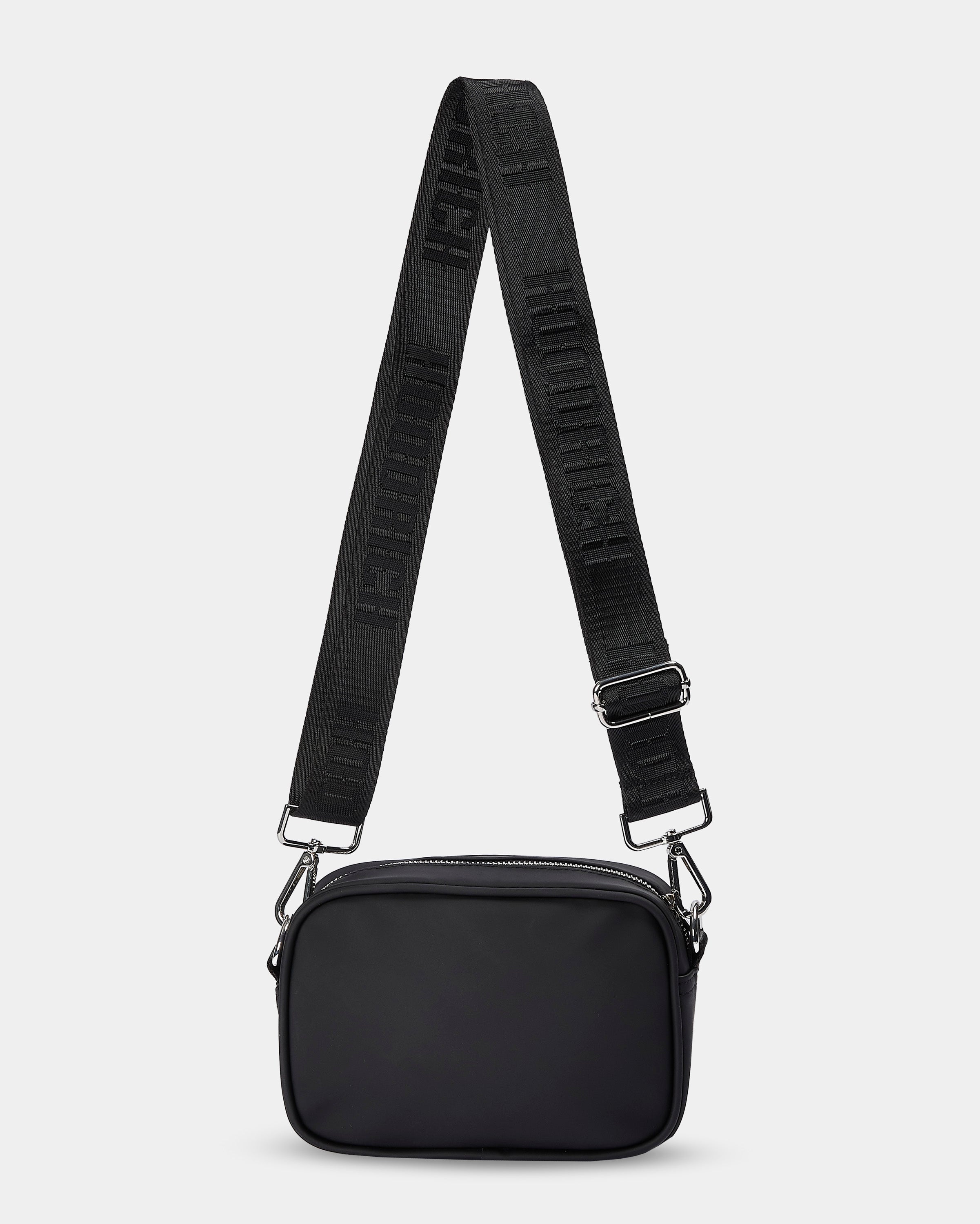 Black crossbody bag with a strap on a light gray background