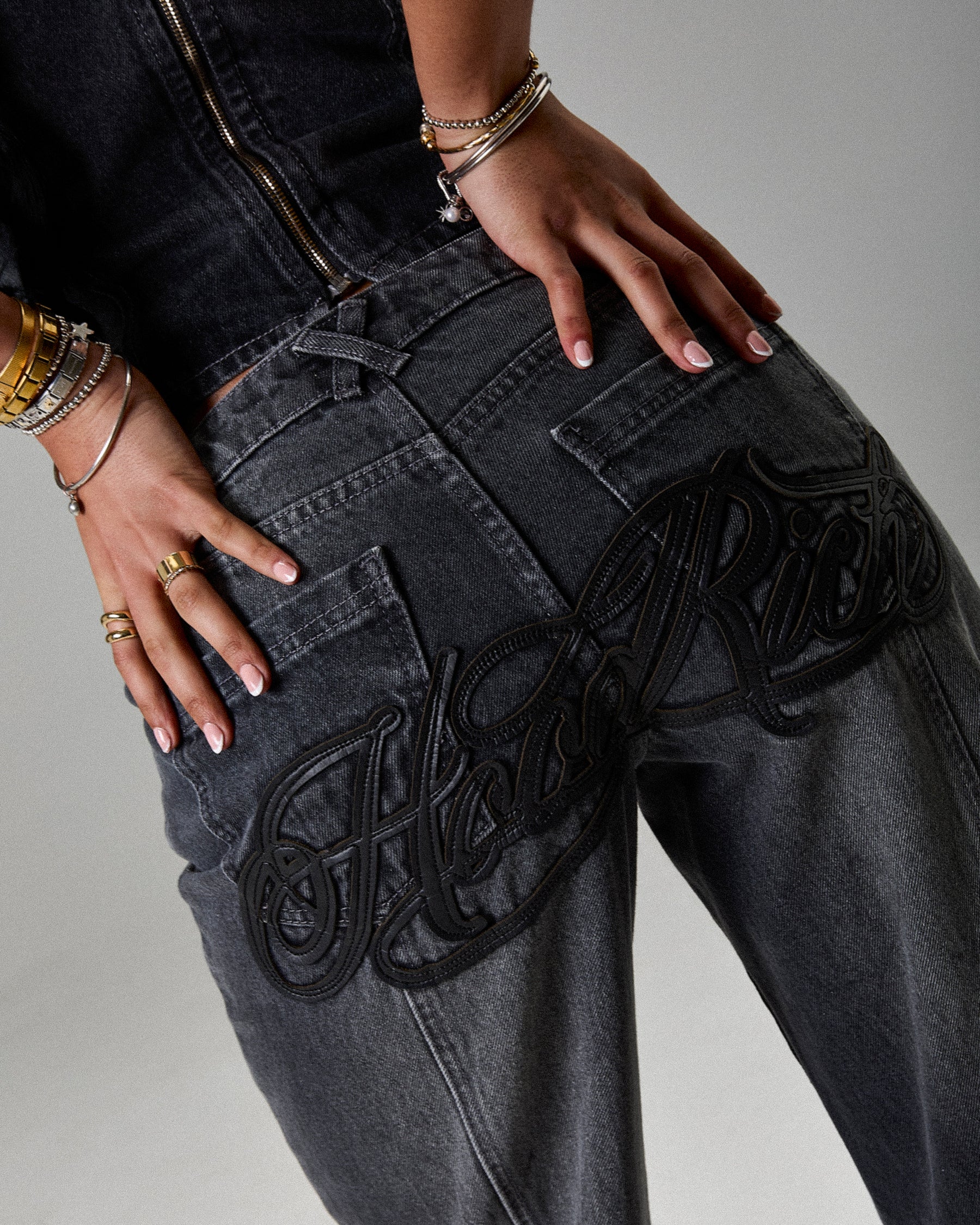 Black jeans with decorative elements on a neutral background