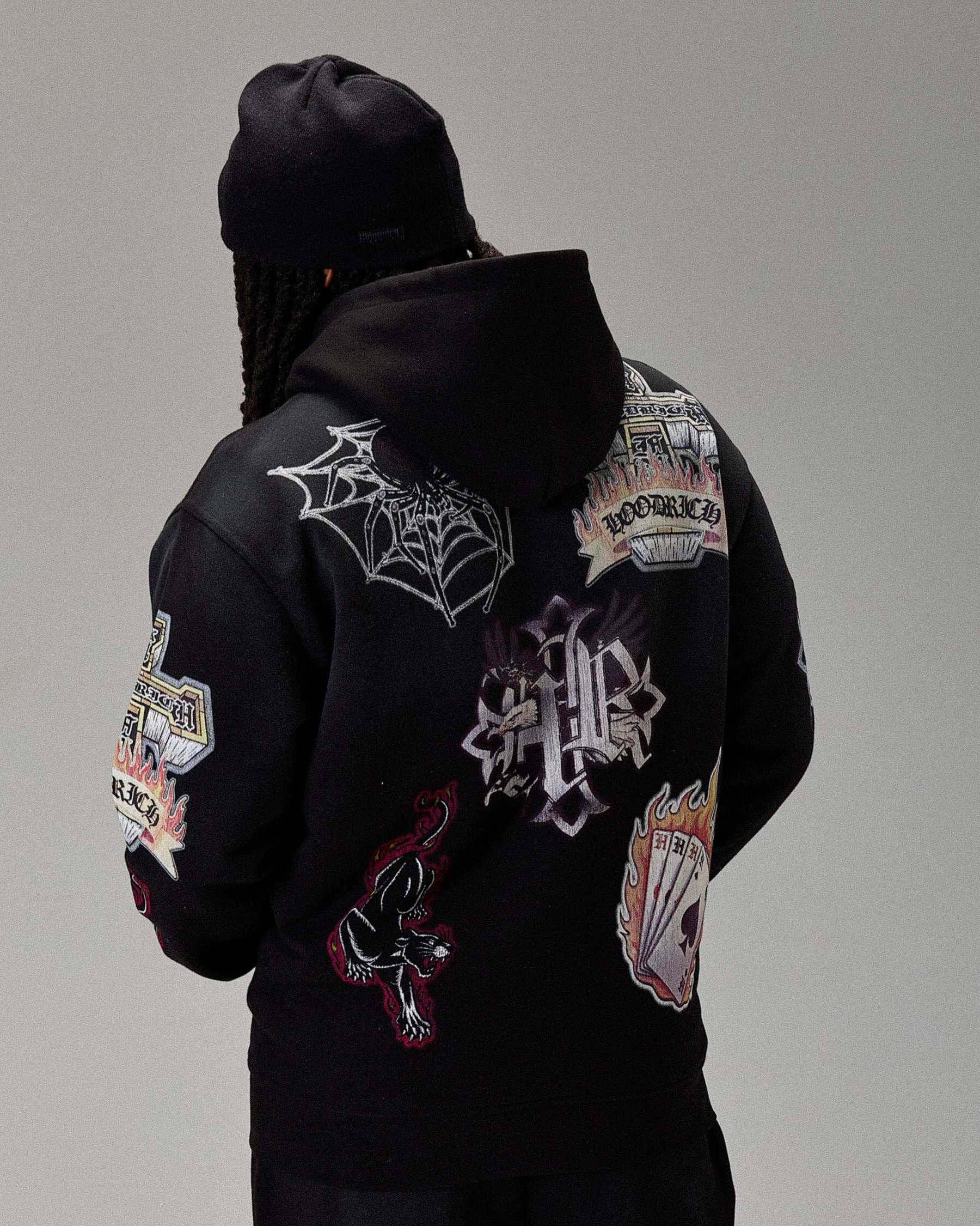 Black hoodie with various patches on a gray background