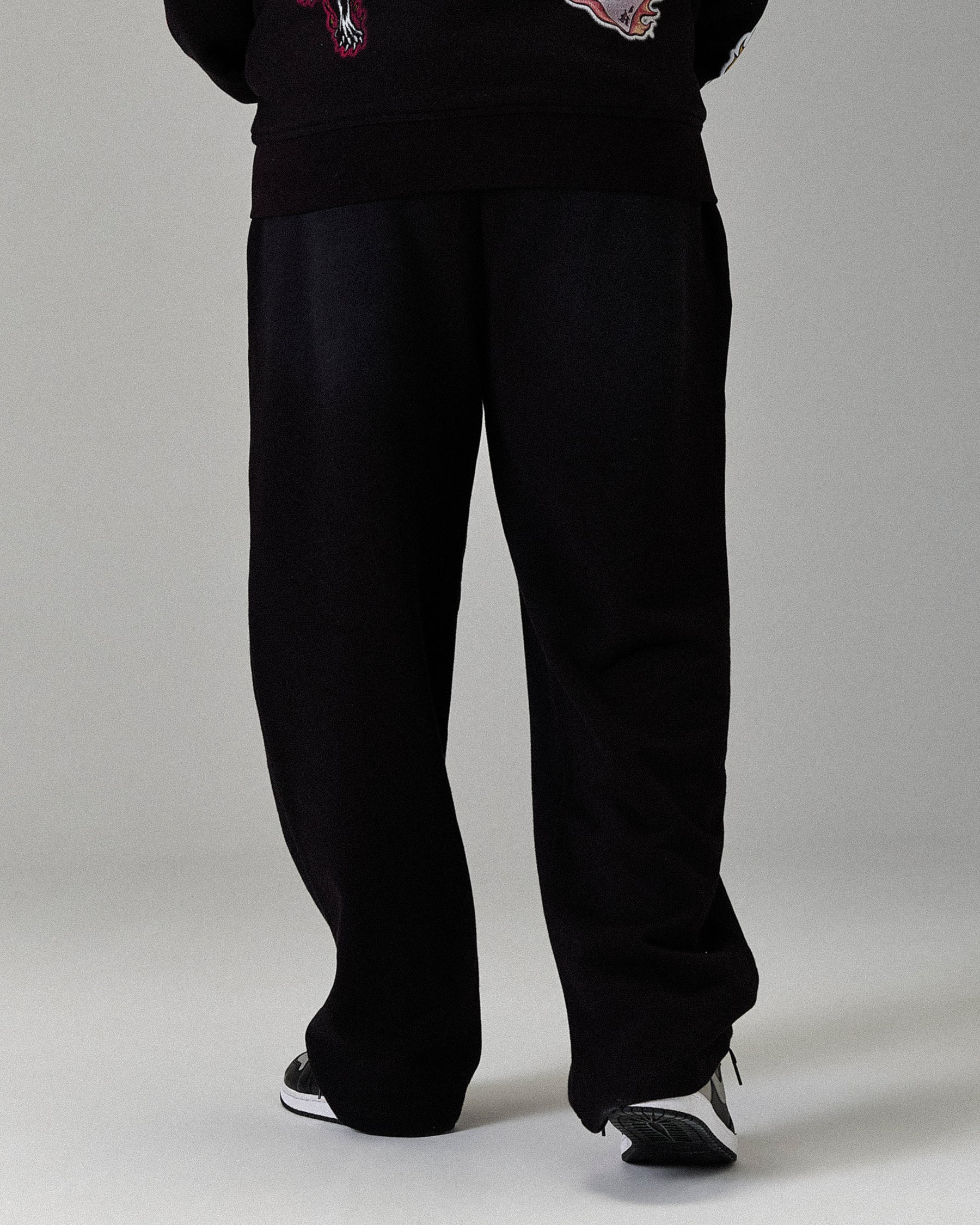 Black pants worn by a person on a plain background