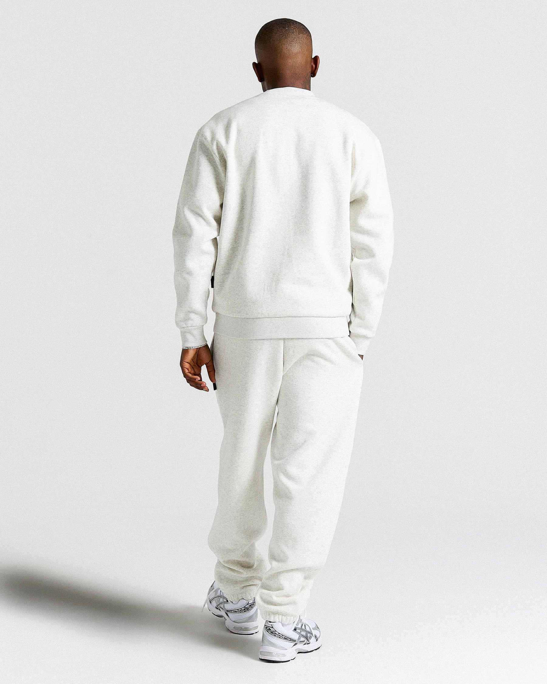 Person wearing a Light Grey tracksuit on a light gray background