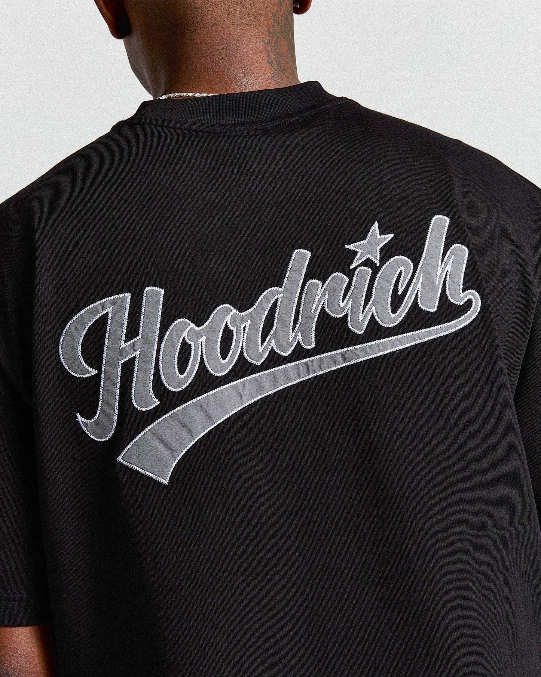 Black t-shirt with 'Hoodrich' logo on the back, worn by a person.