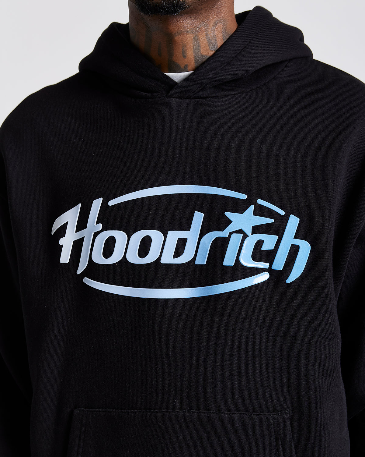 Displays a model wearing the Black 'Hoodrich' branded men's Curve Full Tracksuit featuring the details on the branding 