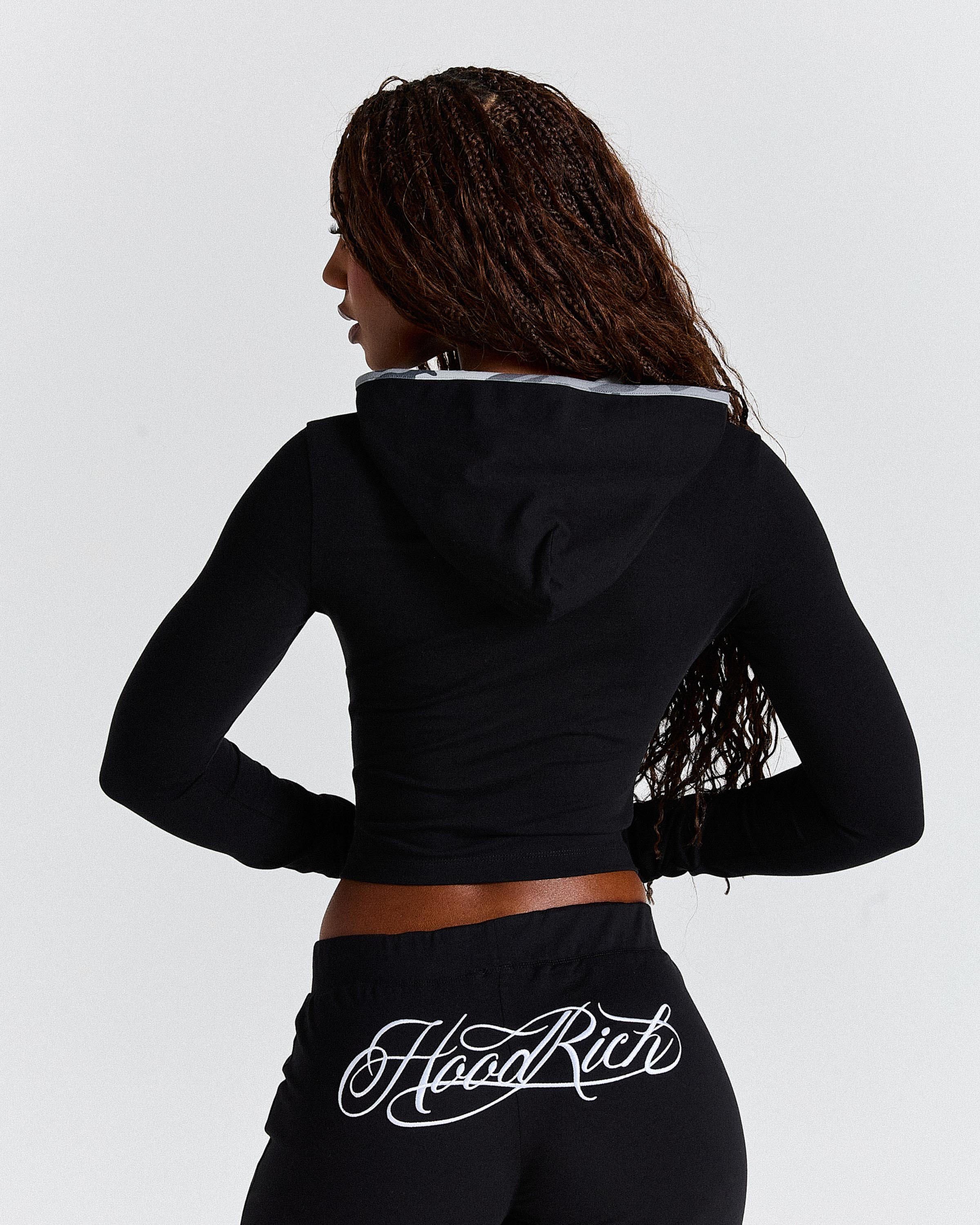 Person wearing a black hoodie with 'Hoodrich' branding on a light gray background