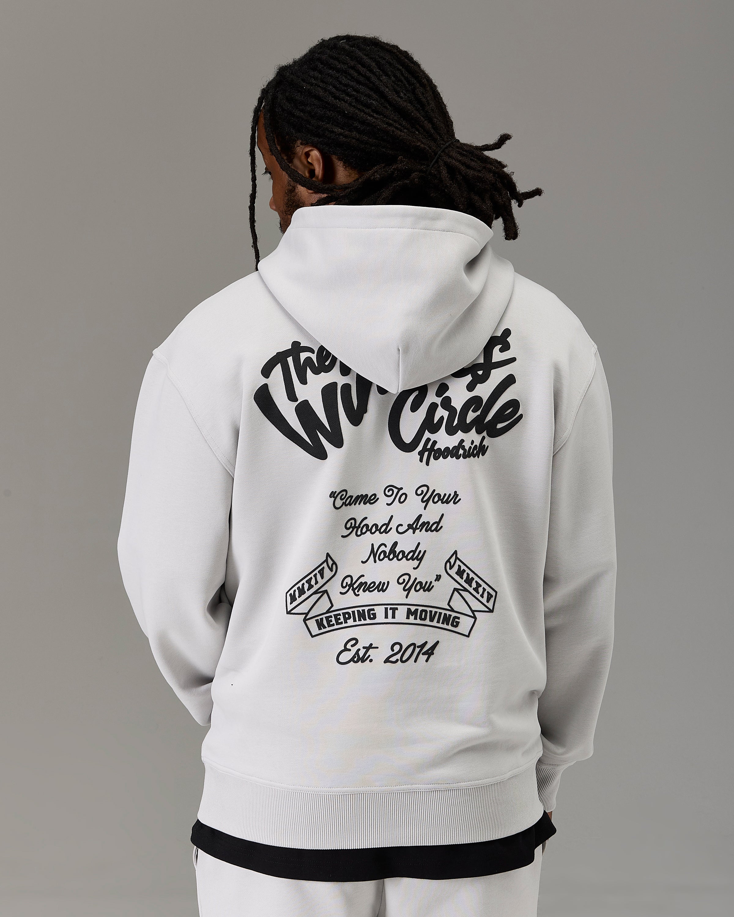 A person shown from the back wearing a white hoodie with a large black graphic print on the back. The hoodie features the text 'The Winners Circle' and additional motivational text.
