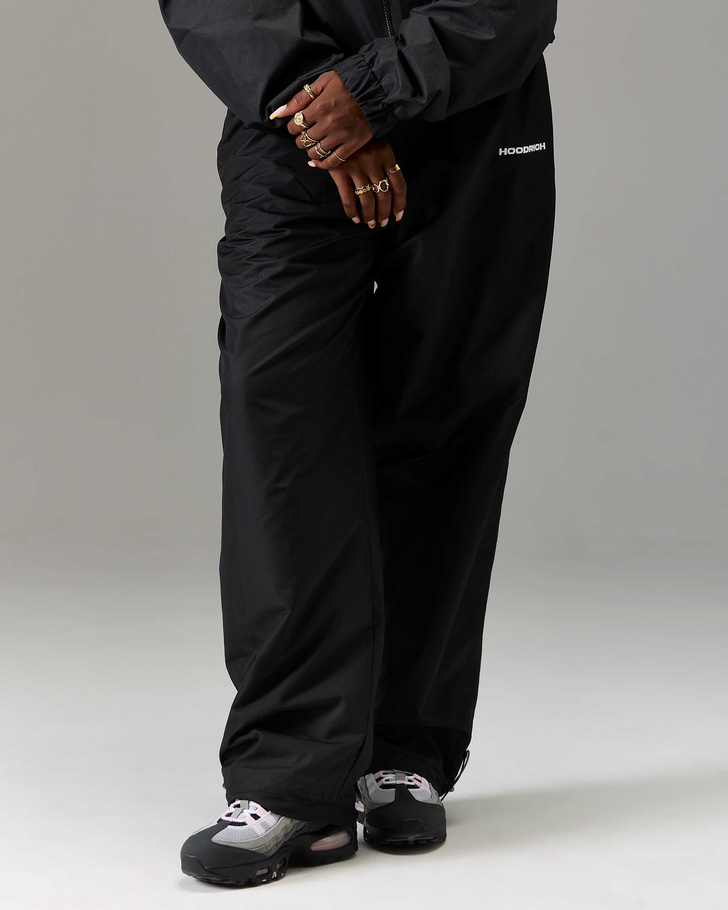 Displays a model wearing the Black 'Hoodrich' branded women's The Winner's Circle Ripstop Woven Full Tracksuit