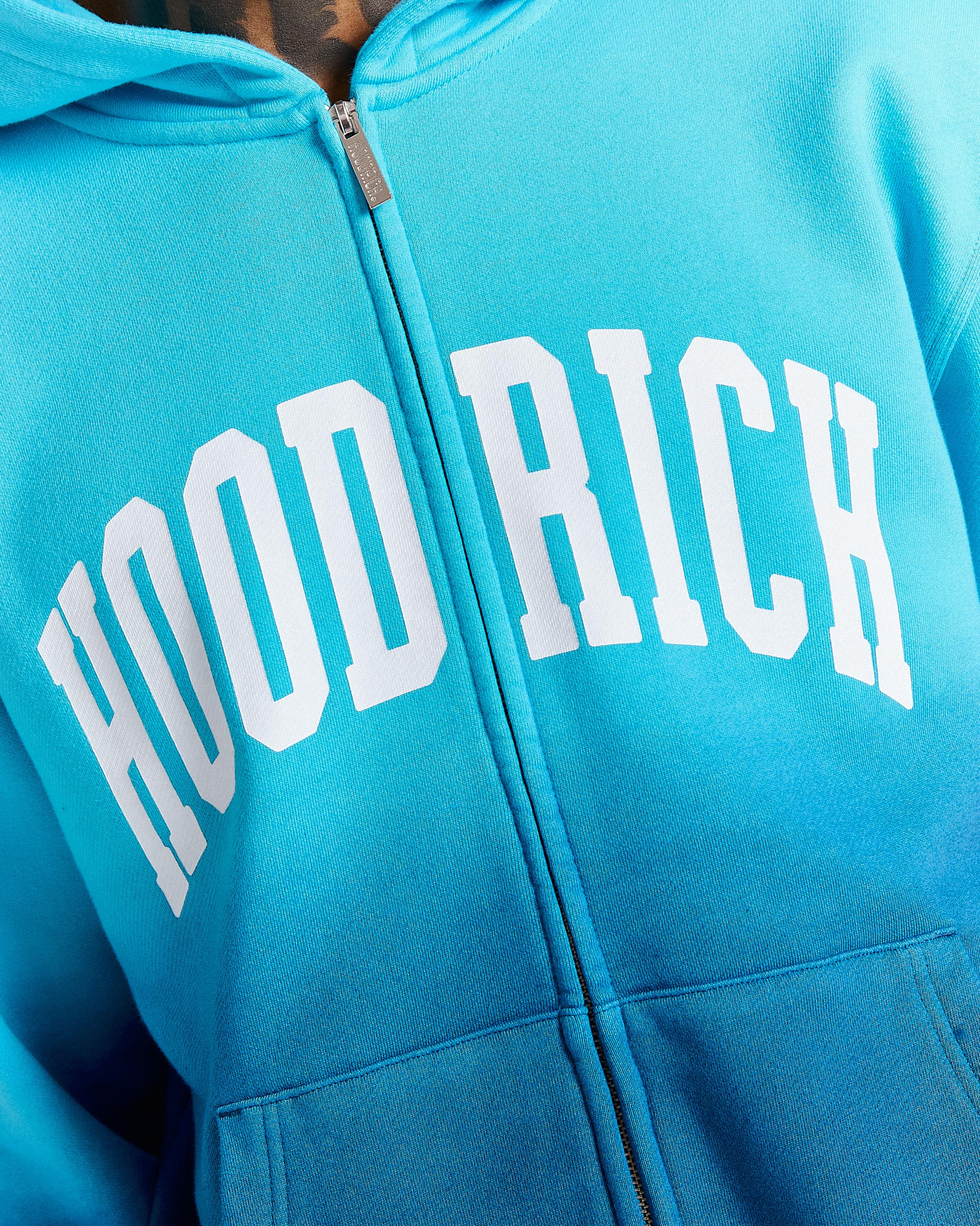 Blue hoodie with 'HOOD RICH' text on a close-up view