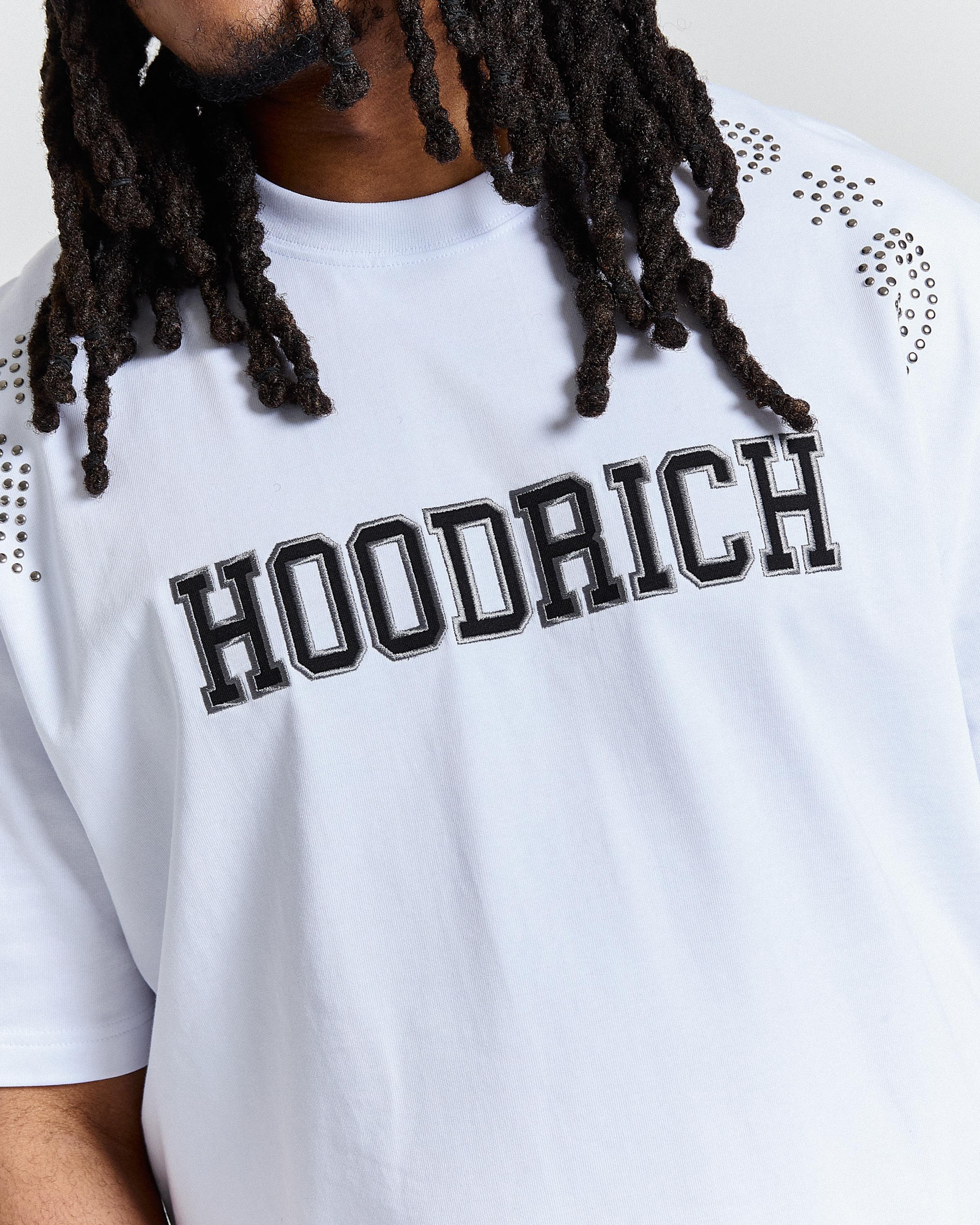 Person wearing a white t-shirt with 'HOODRICH' printed on it.