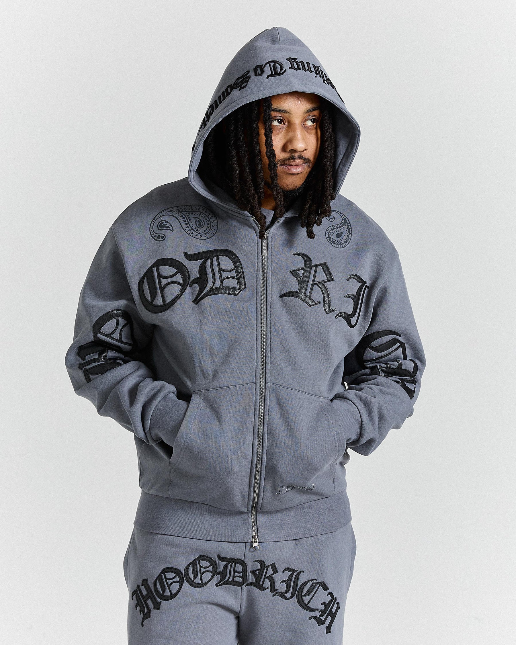 Person wearing a gray hoodie with branding on a white background